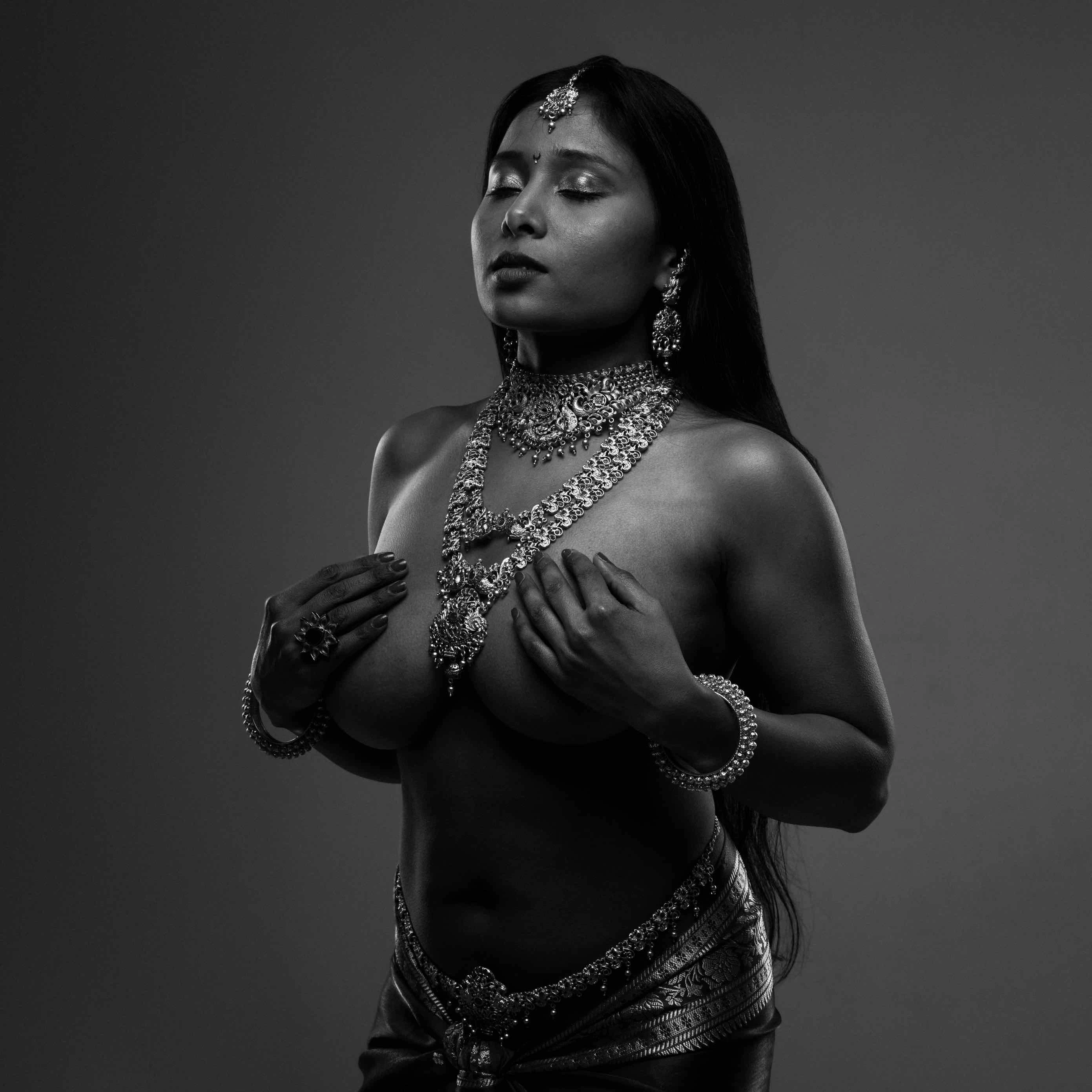 Desi dusky model wearing large necklace and posing topless and hiding her big tits with her hands