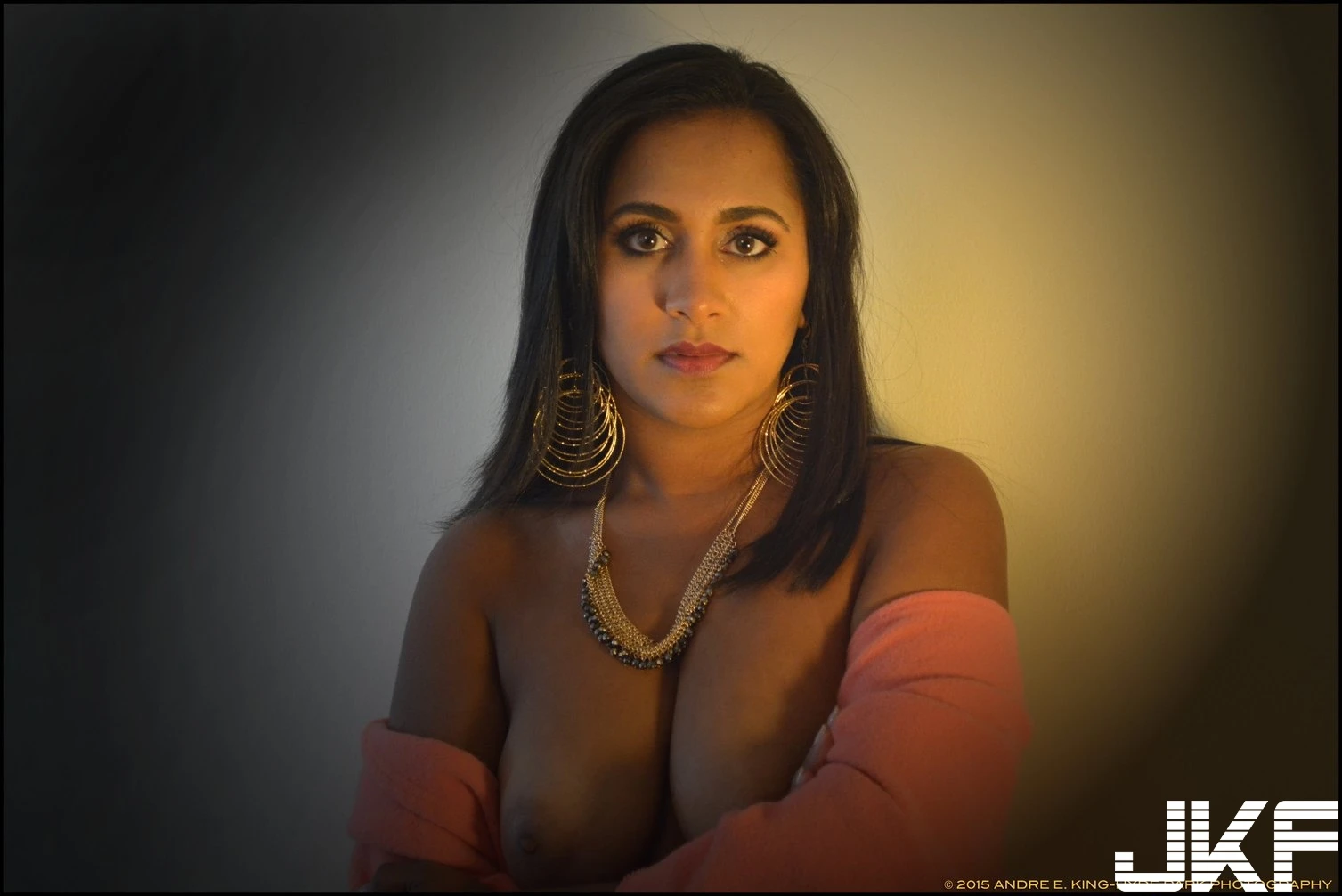 Indian MILF beauty revealing her huge boobs posing in an orange shawl and big earrings and necklace