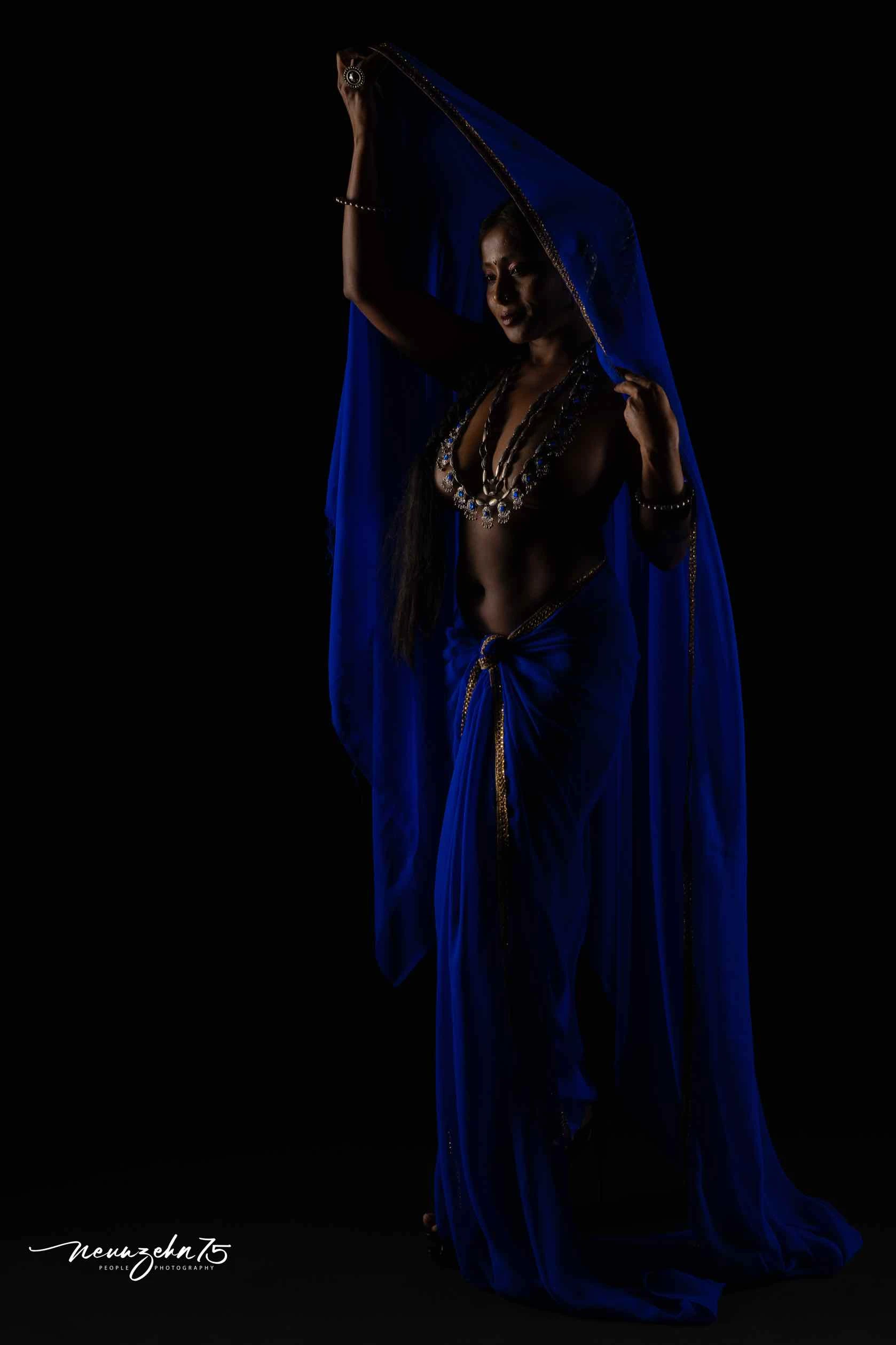 Desi model posing topless wearing heavy jewellery and hiding her big boobs while wearing a blue saree