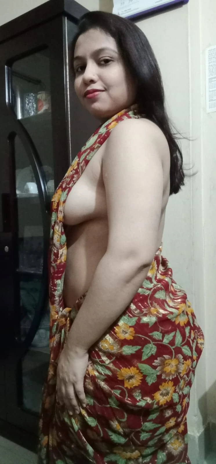 Desi wife tantalizes with her bosoms peeking out of her braless floral saree
