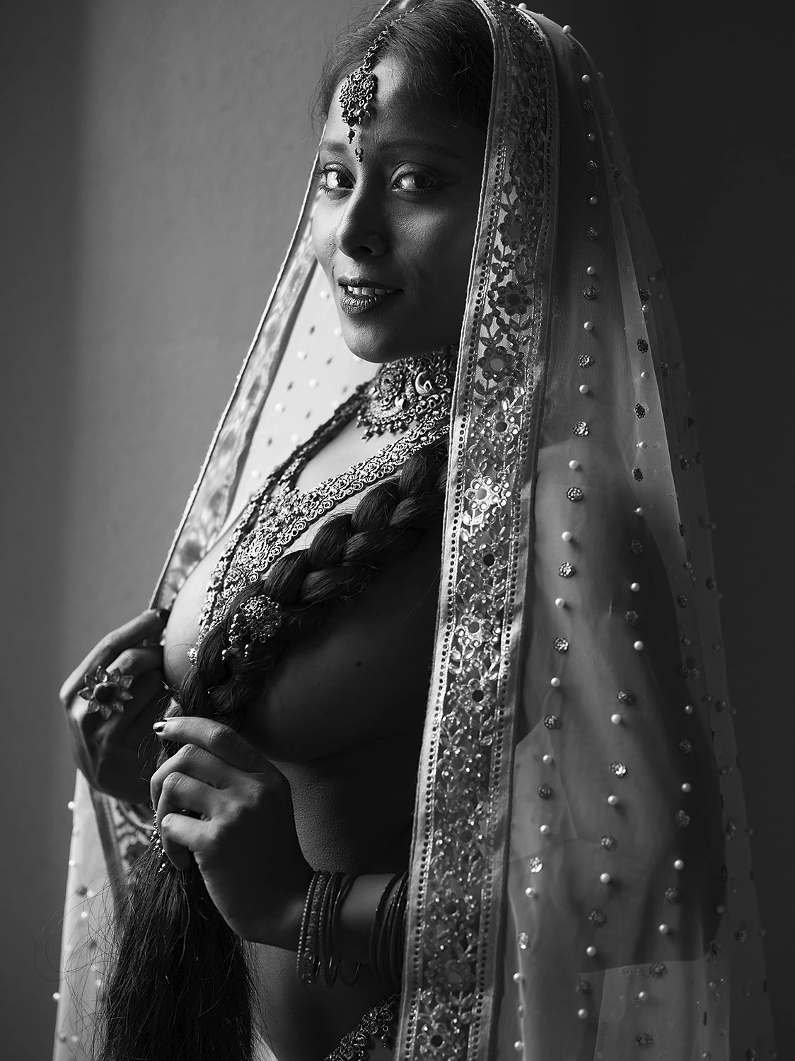 Desi model with veil on her head posing topless wearing jewellery and hiding her big tits with her braid