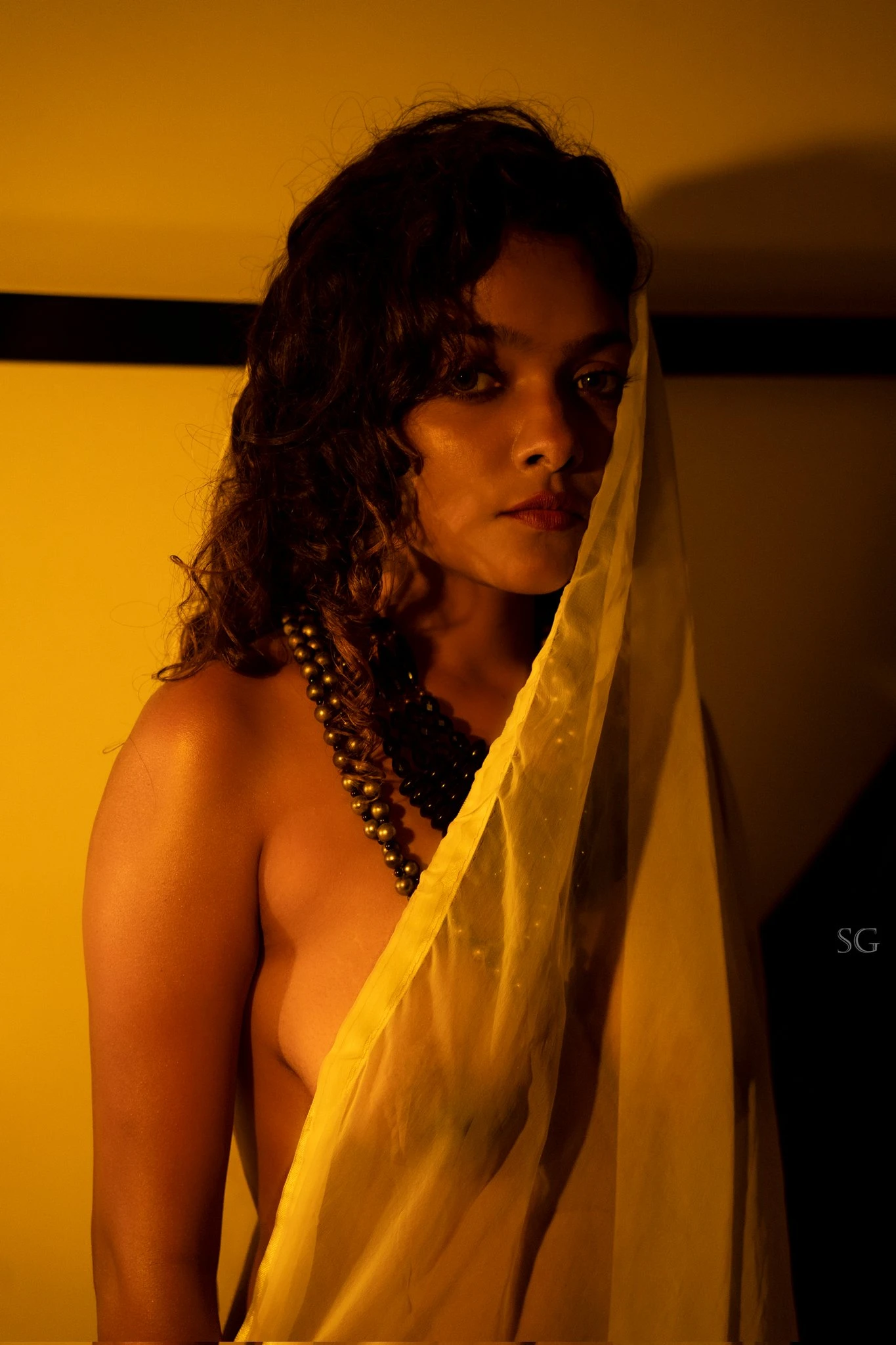 Desi MILF model shows her boobs wearing just a thin braless yellow saree