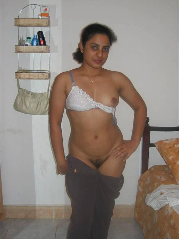 Sultry Desi MILF takes out one of her petite boobs from the bra and pulls down her pants to show her hairy pussy