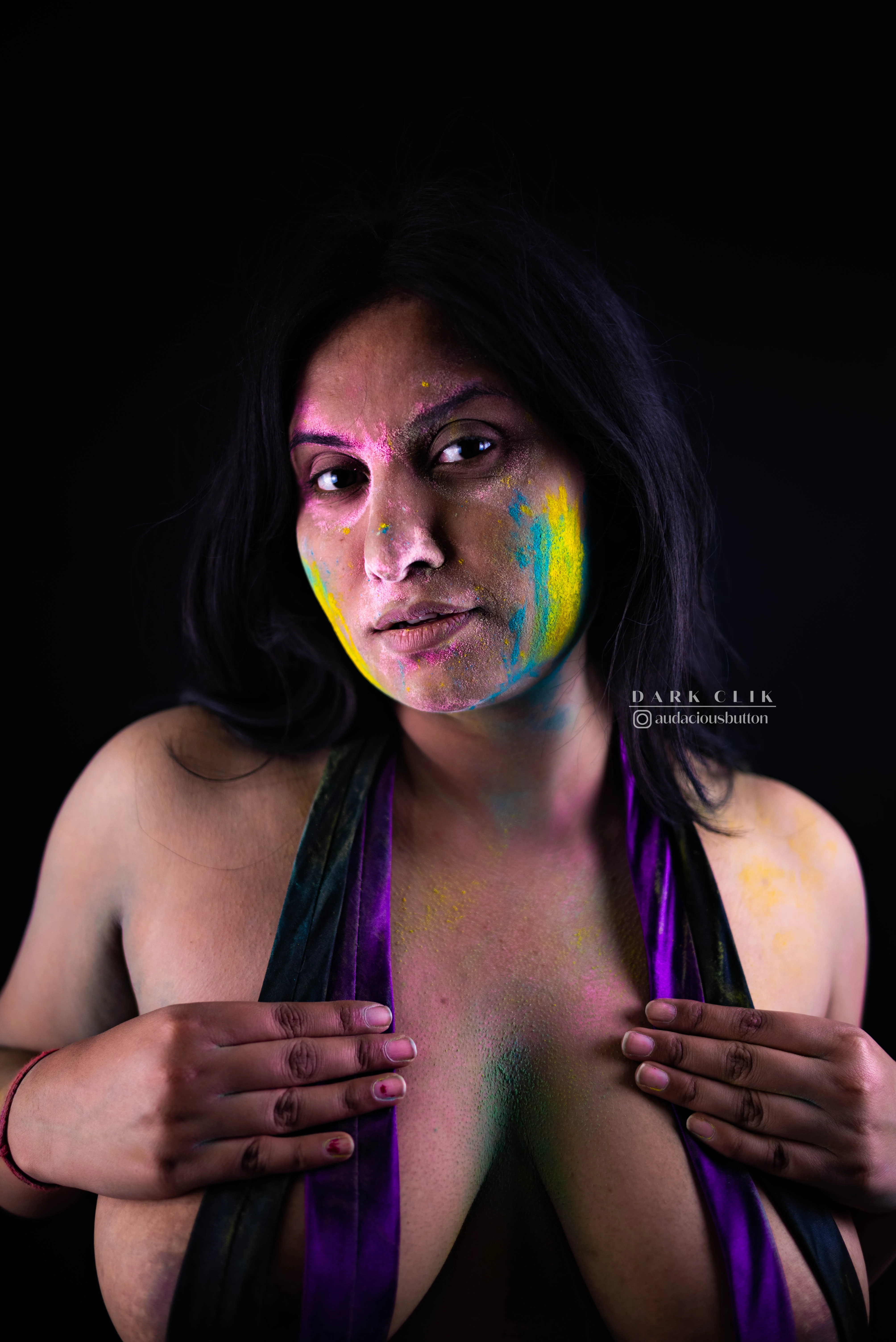 Desi MILF model with holi colors on her face hides her big boobs with a purple cloth