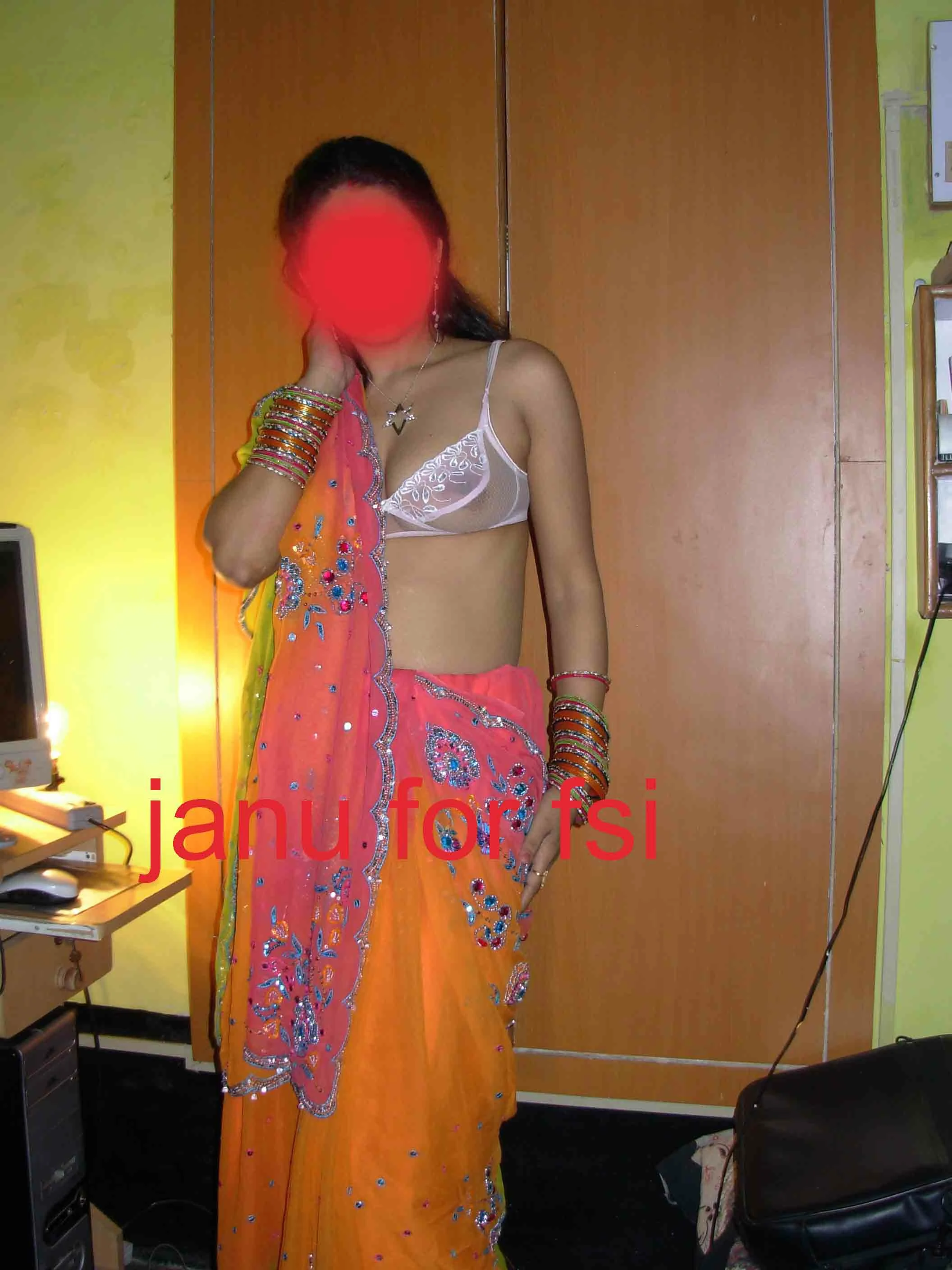 Desi wife shows her big boobs in a transparent white bra while posing in an orange saree