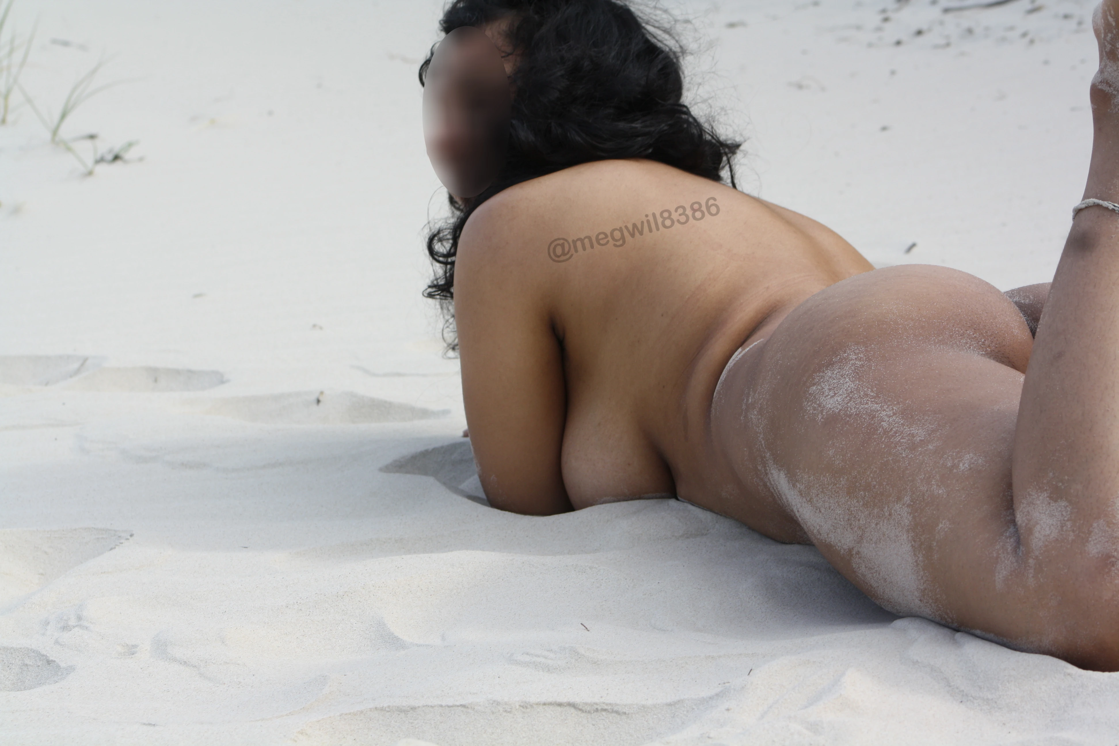 Indian MILF wife baring it all and temptingly showing her side breasts and ass while lying on the sands in a beach