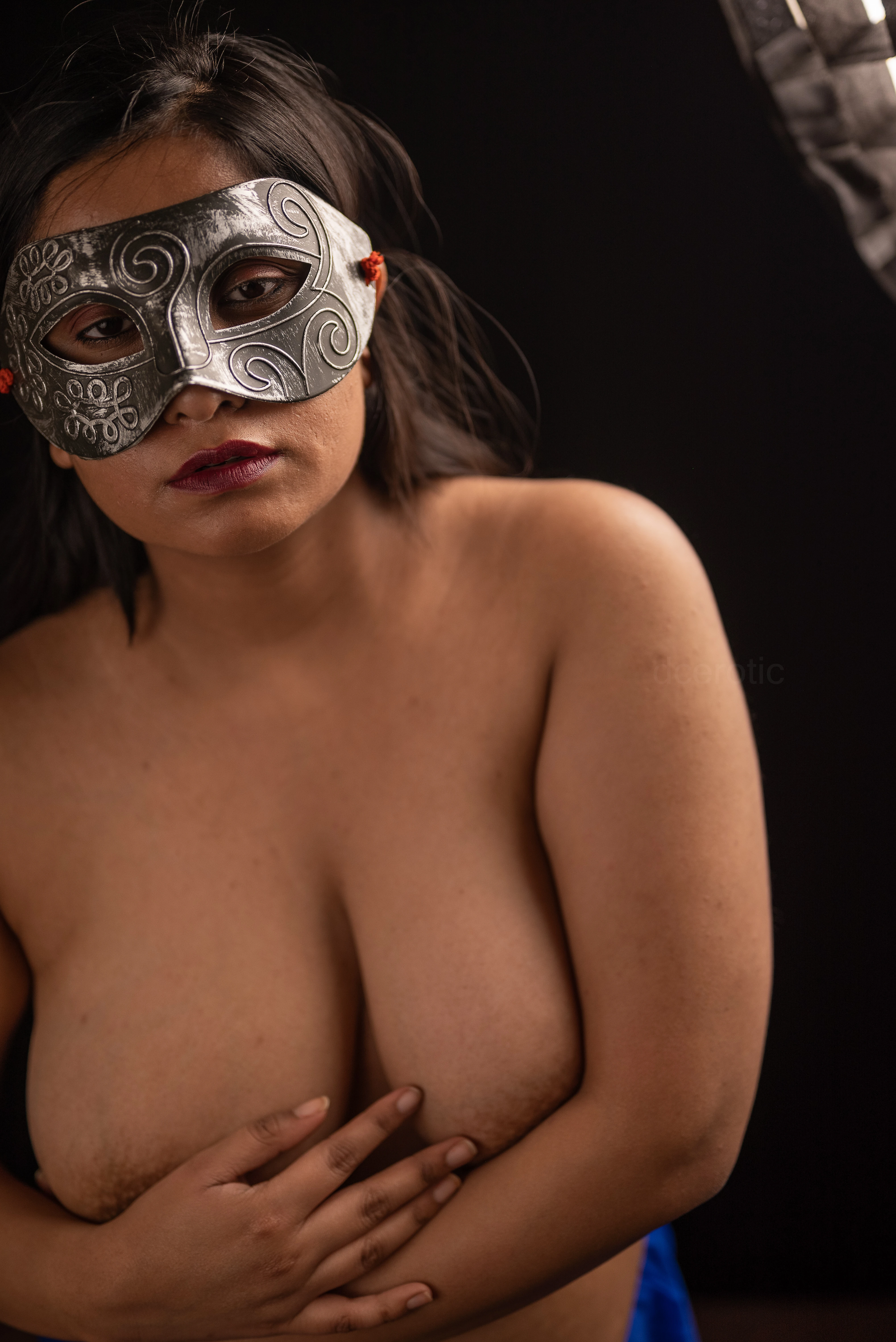 Desi MILF model covers her topless big boobs with her hands while wearing eye mask and blue petticoat