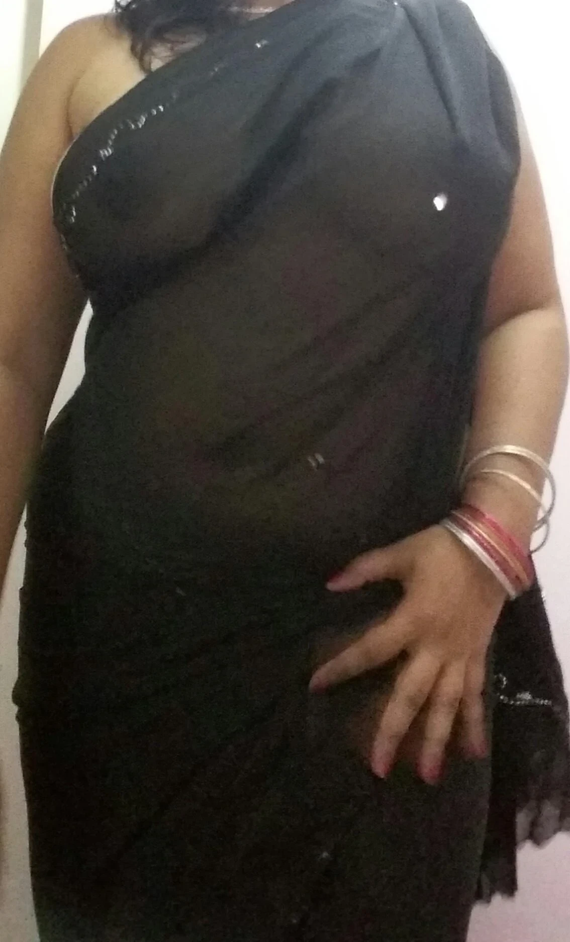Sexy Desi MILF shows off her big boobs in a braless black transparent saree