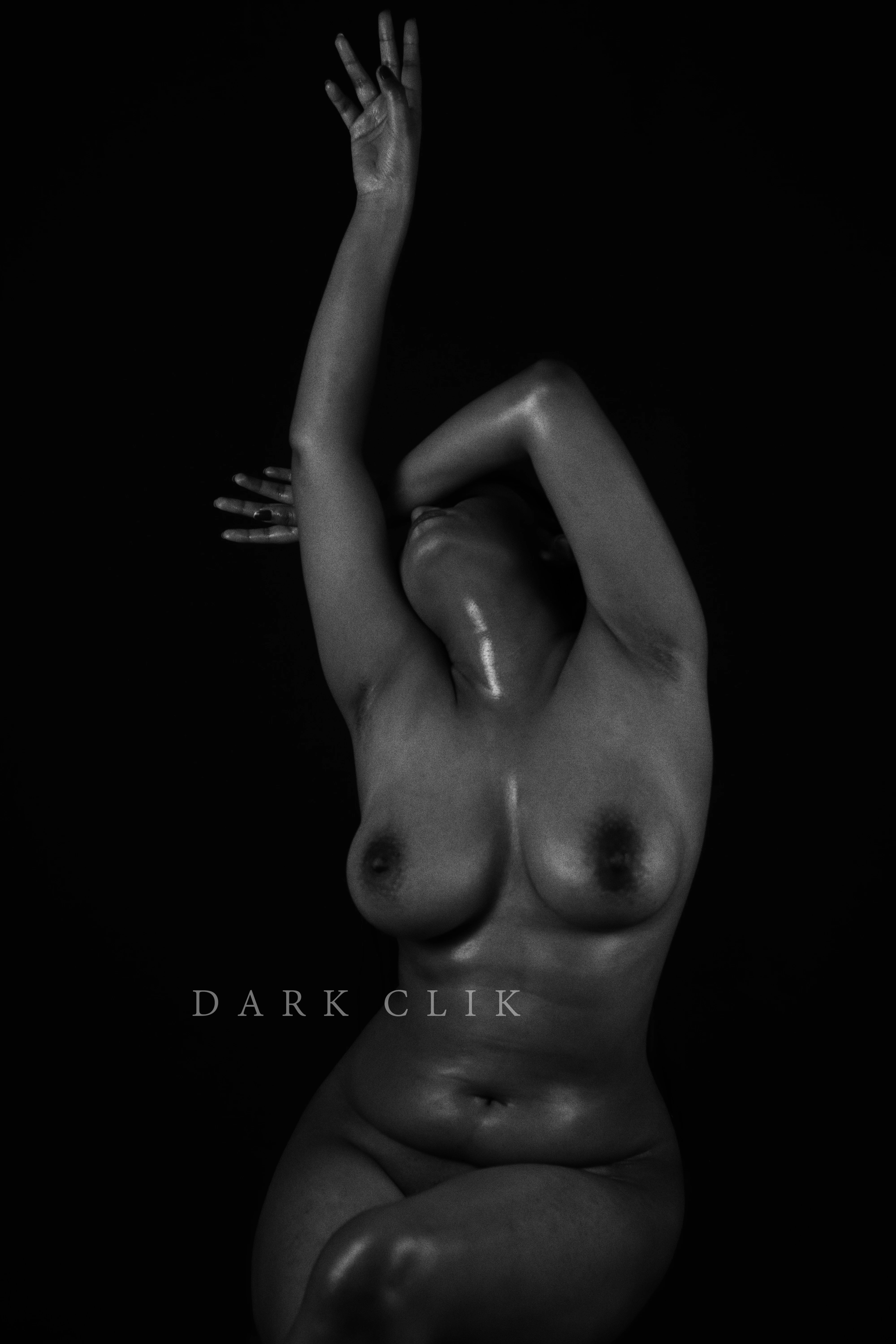 Naked Indian model with raised hand and covering her face revealing her ample bosom and hides her snatch in an erotic photoshoot