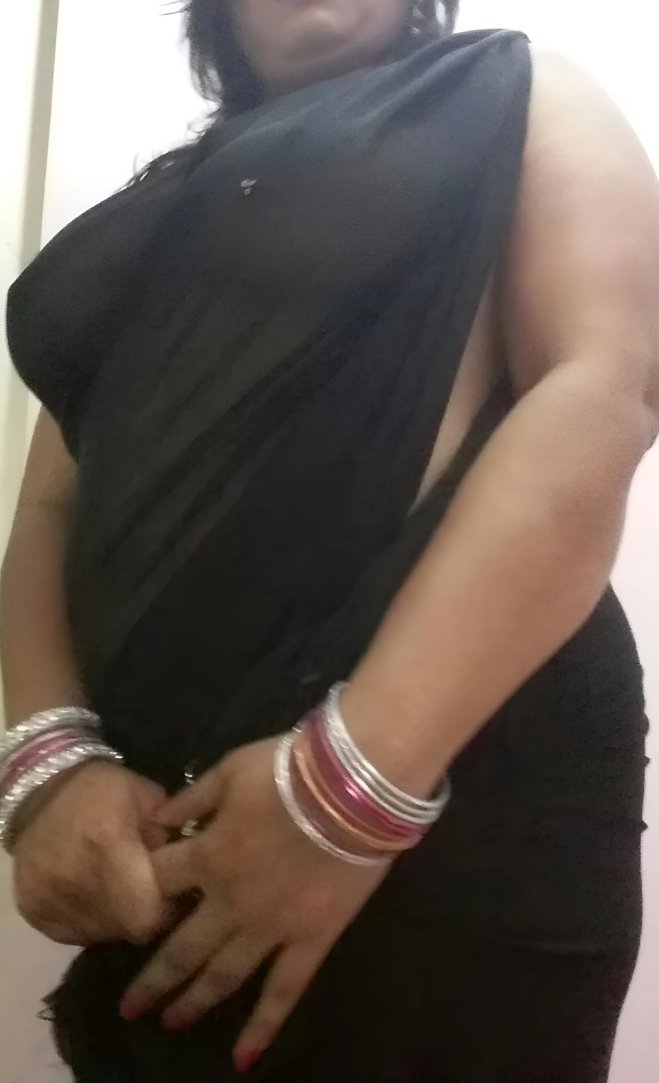 Sexy Desi MILF shows off her big jutting tits in a braless black transparent saree