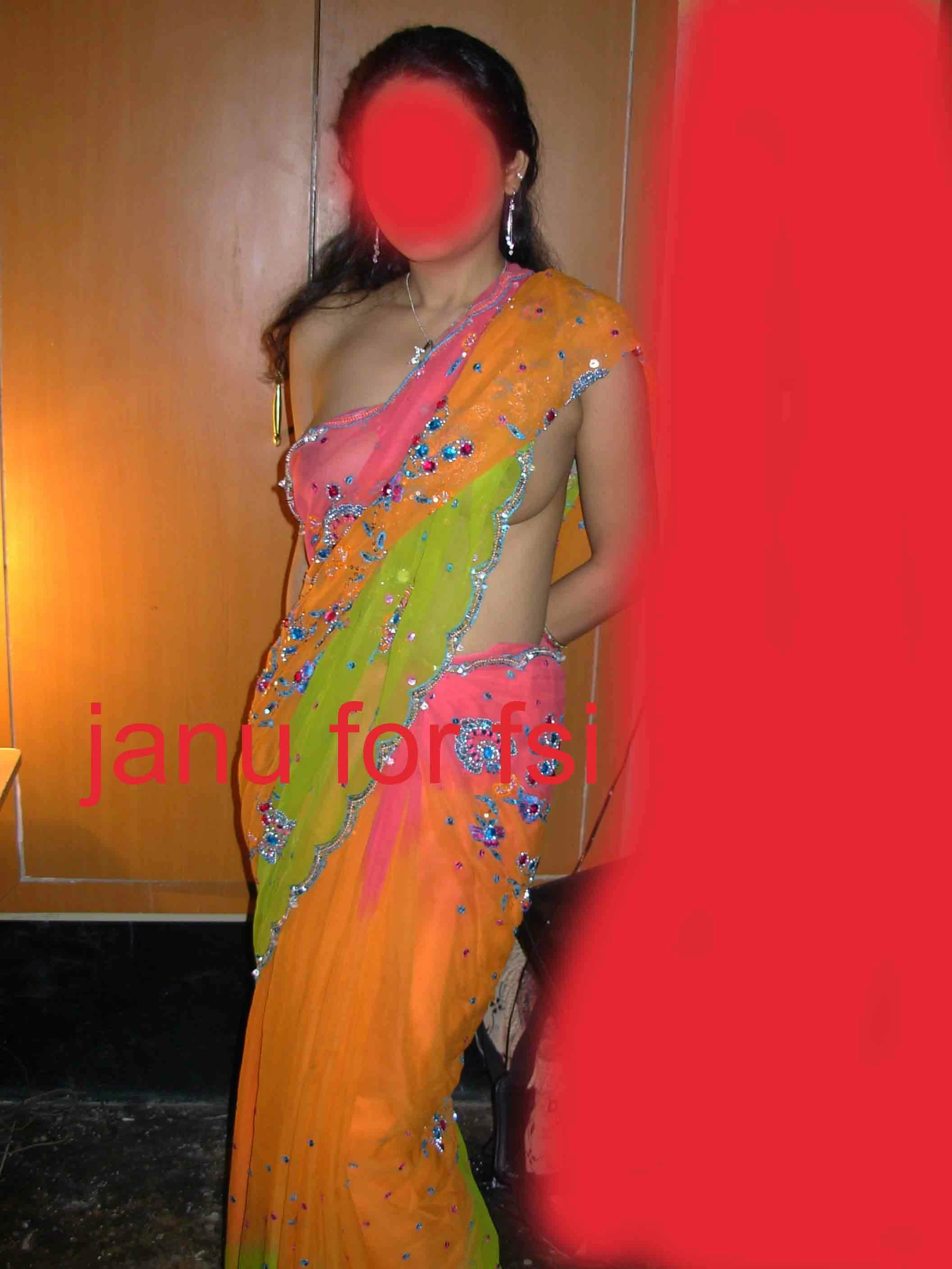 Desi wife showing her slim beauty while posing in an orange braless saree