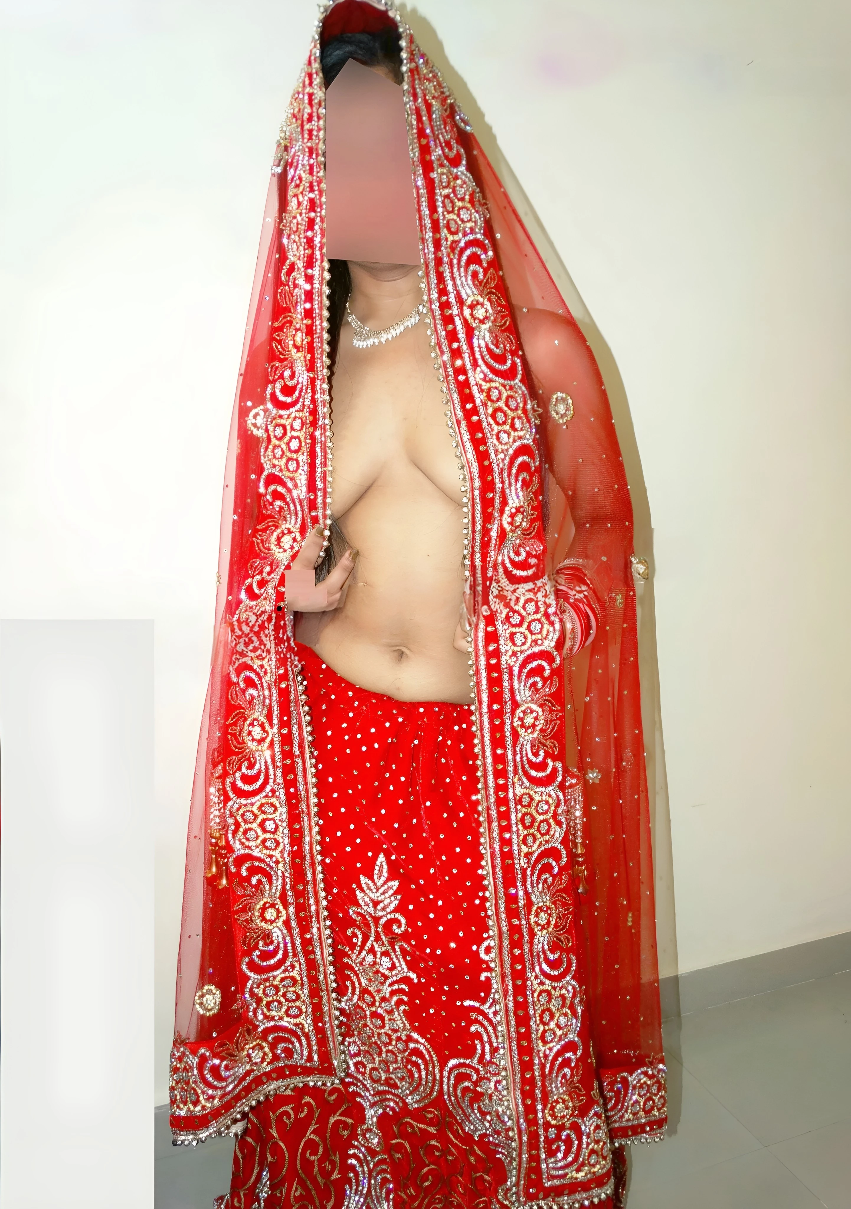 Exotic Desi wife posing topless and showing glimpses of her boobs in a braless red bridal saree