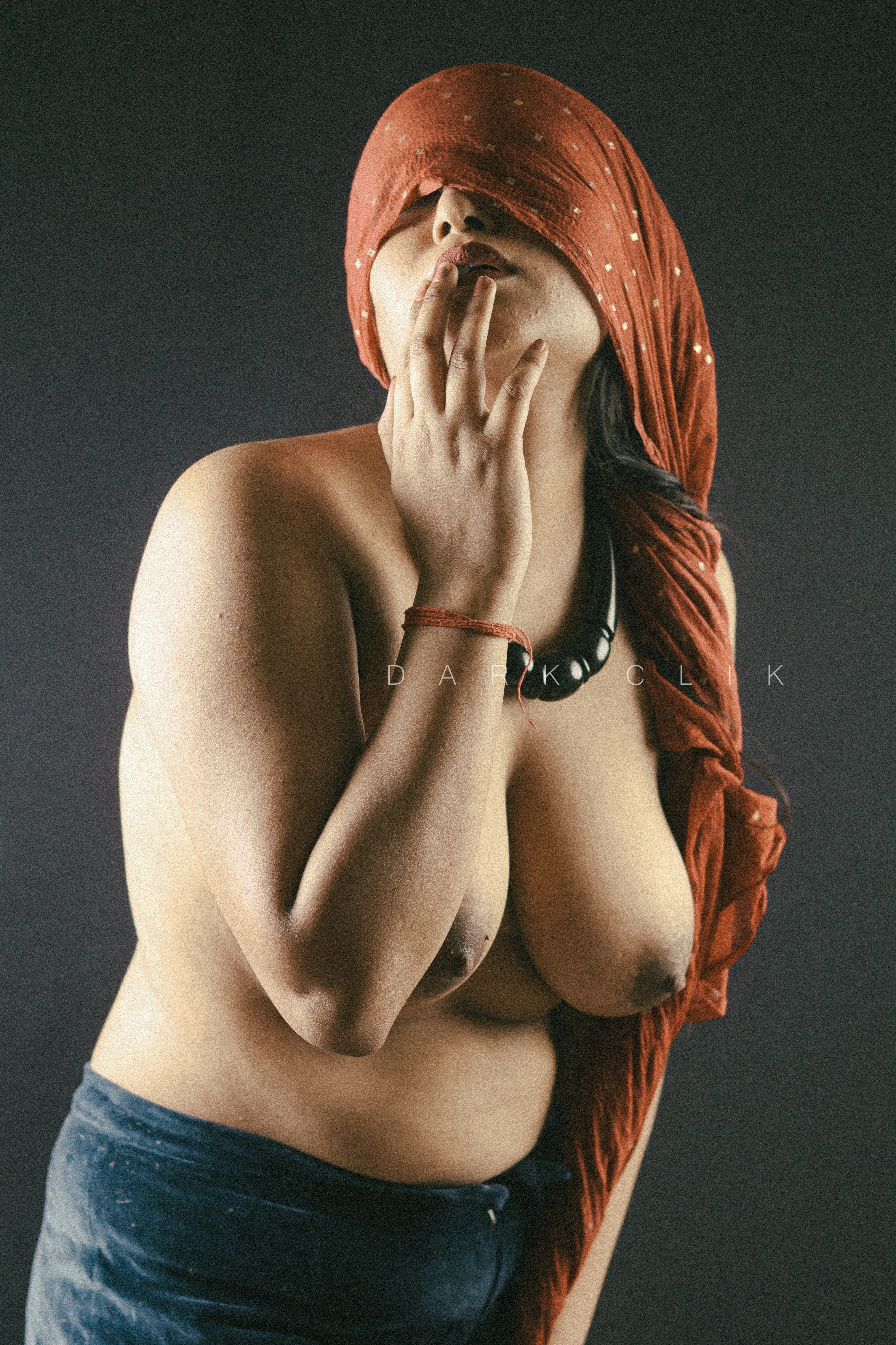 Desi MILF model shows her big topless boobs wearing blue pants and hiding the top of her face with red cloth