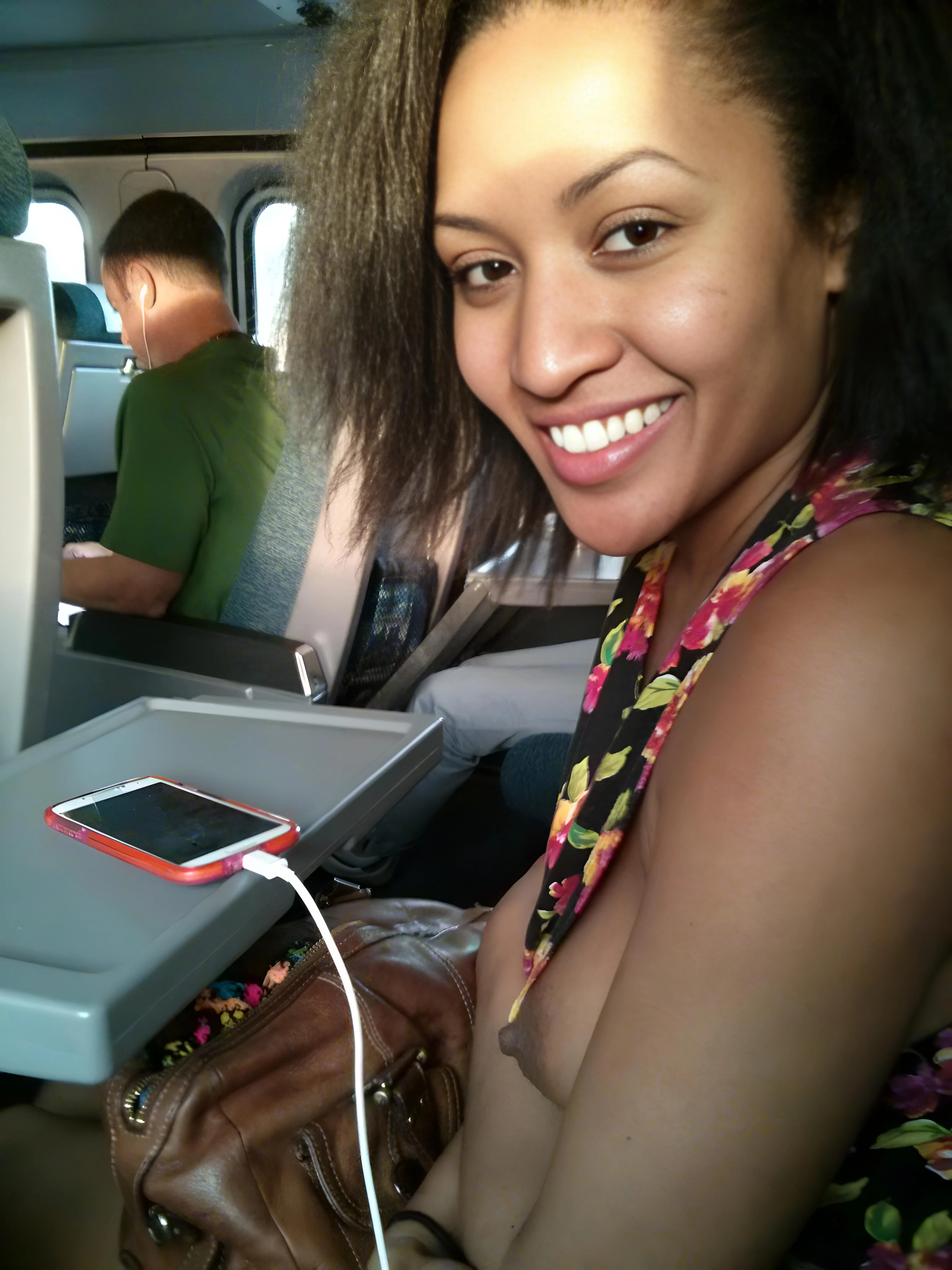 Brazen and bold lady pushes aside her tops to reveal her perky tits inside an airplane