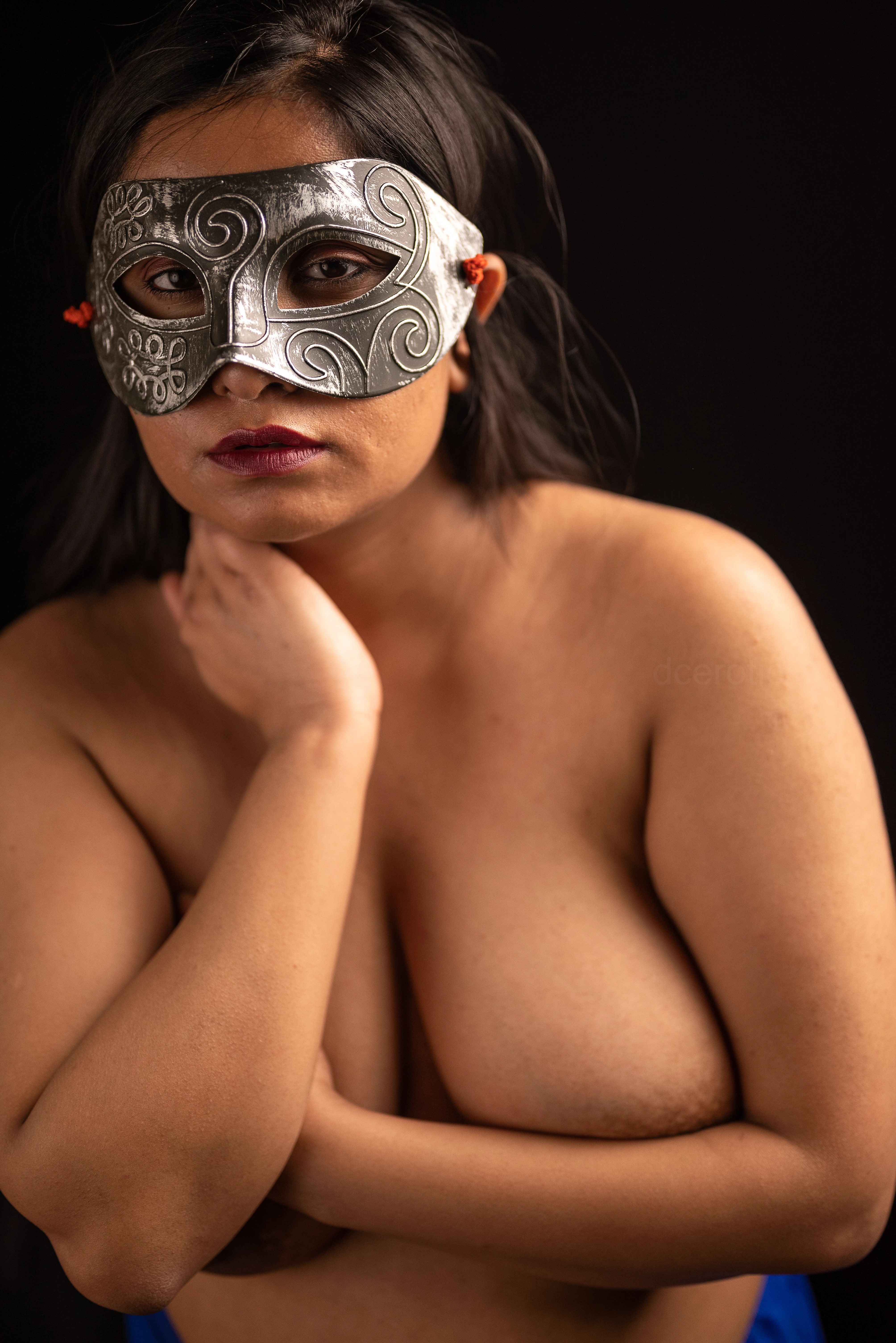 Desi MILF model barely covers her big topless breasts with her hands while wearing eye mask and blue petticoat