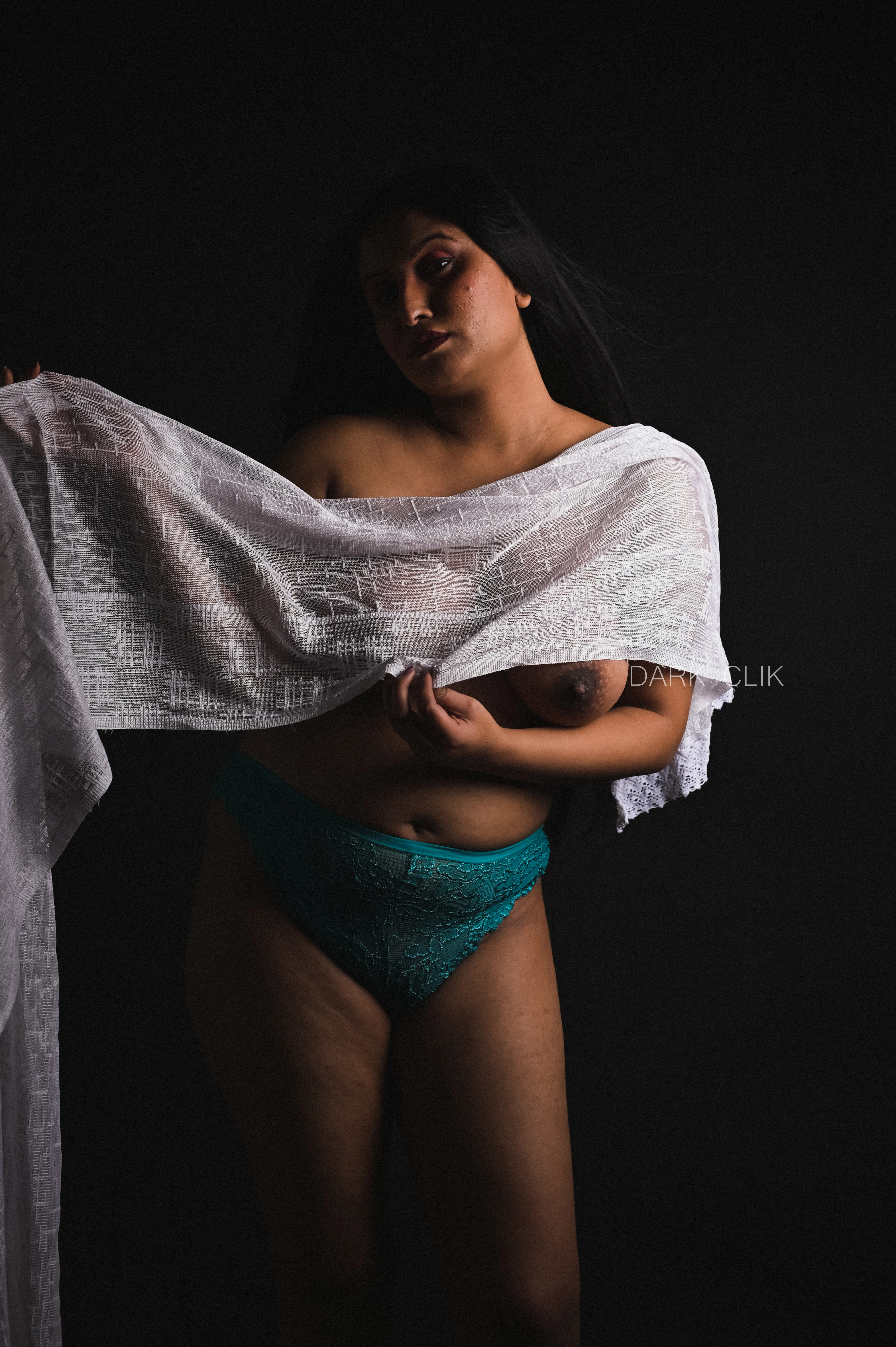 Desi MILF model trying to cover her topless big tits with a white cloth and posing in green panties