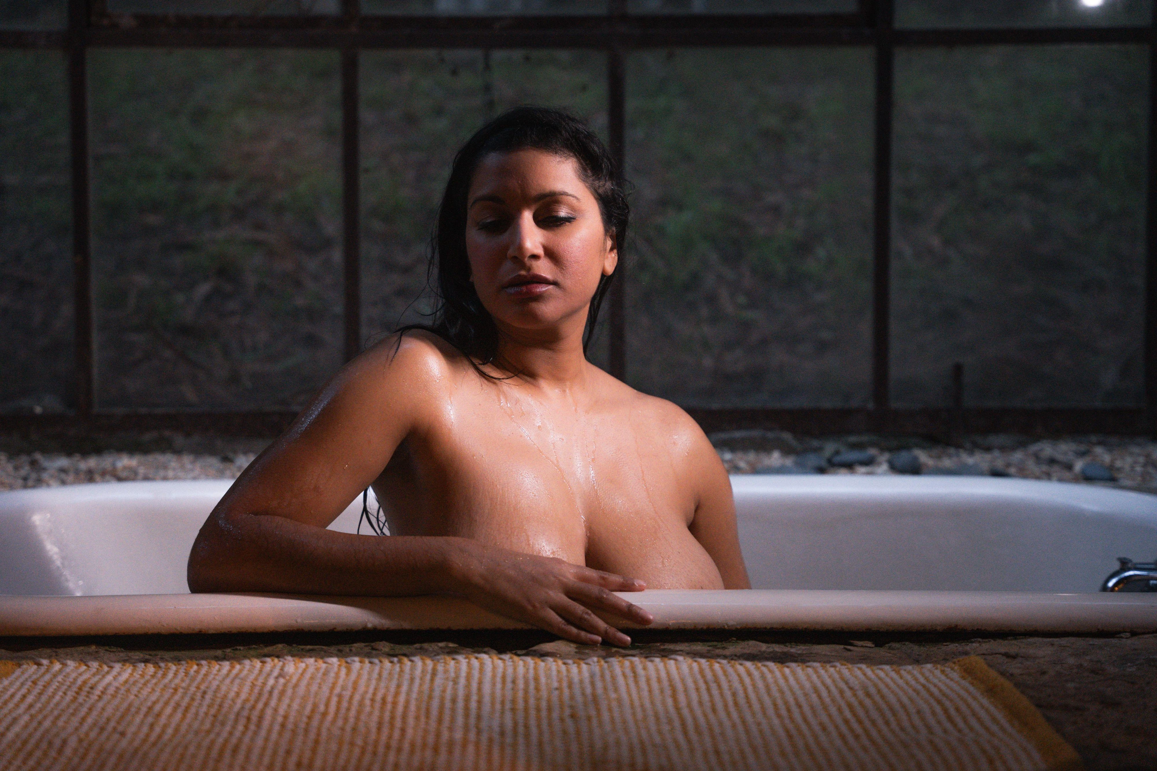Desi model posing inside a bath tub and sexily showing top of her big boobs