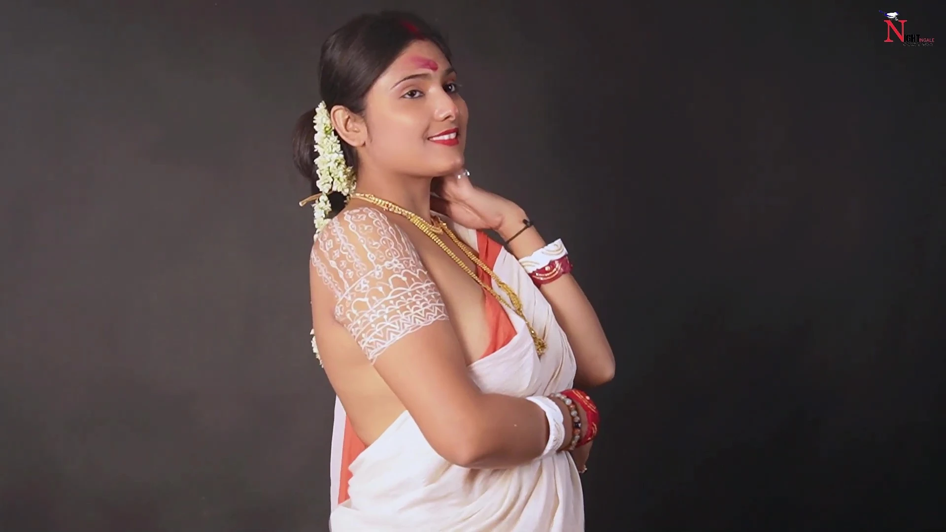 Desi MILF model wearing mangalsutra poses in a braless red bordered white saree and covers her boobs with it