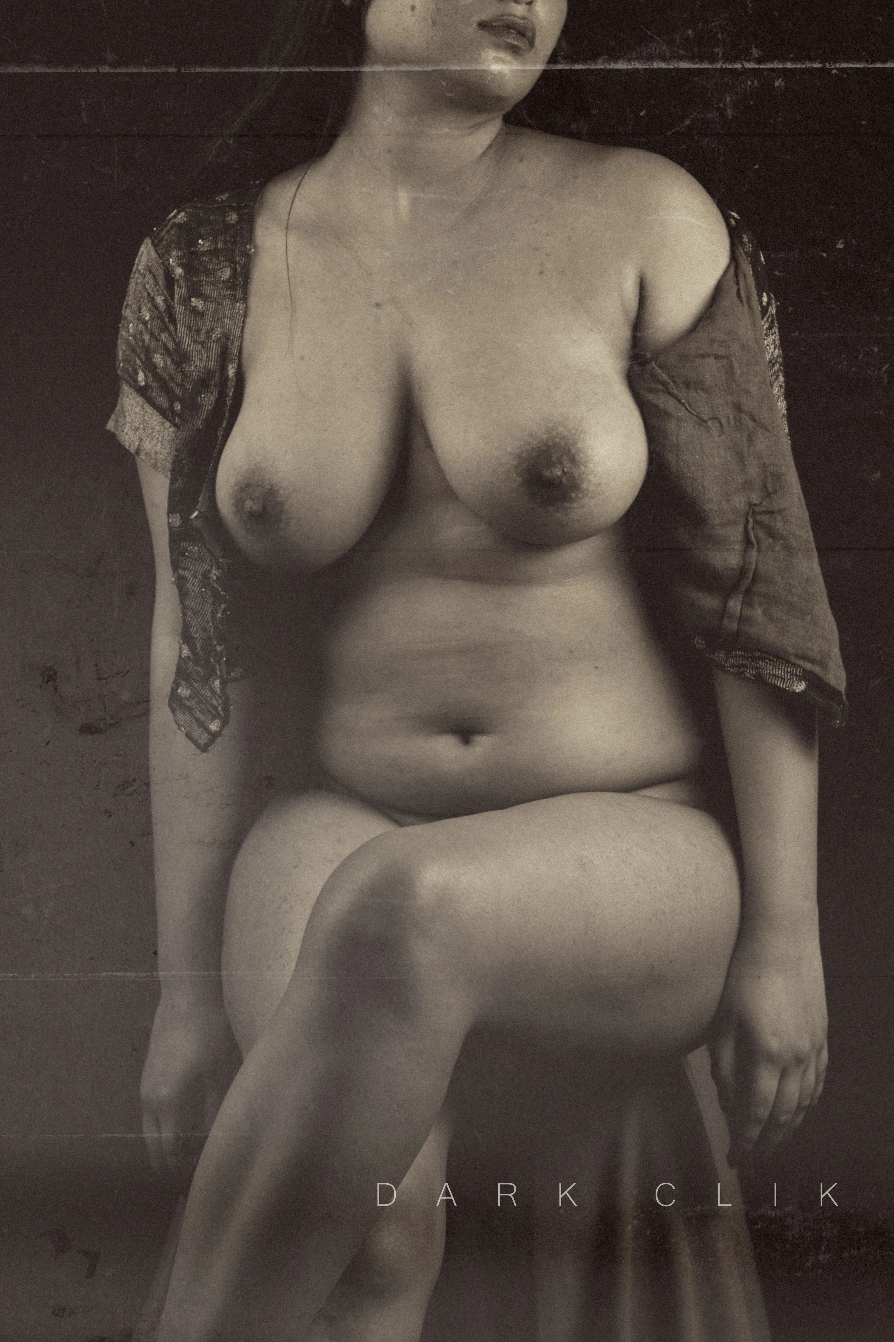 Desi MILF shows her bold and big beautiful melons in an open blouse while sitting on a stool
