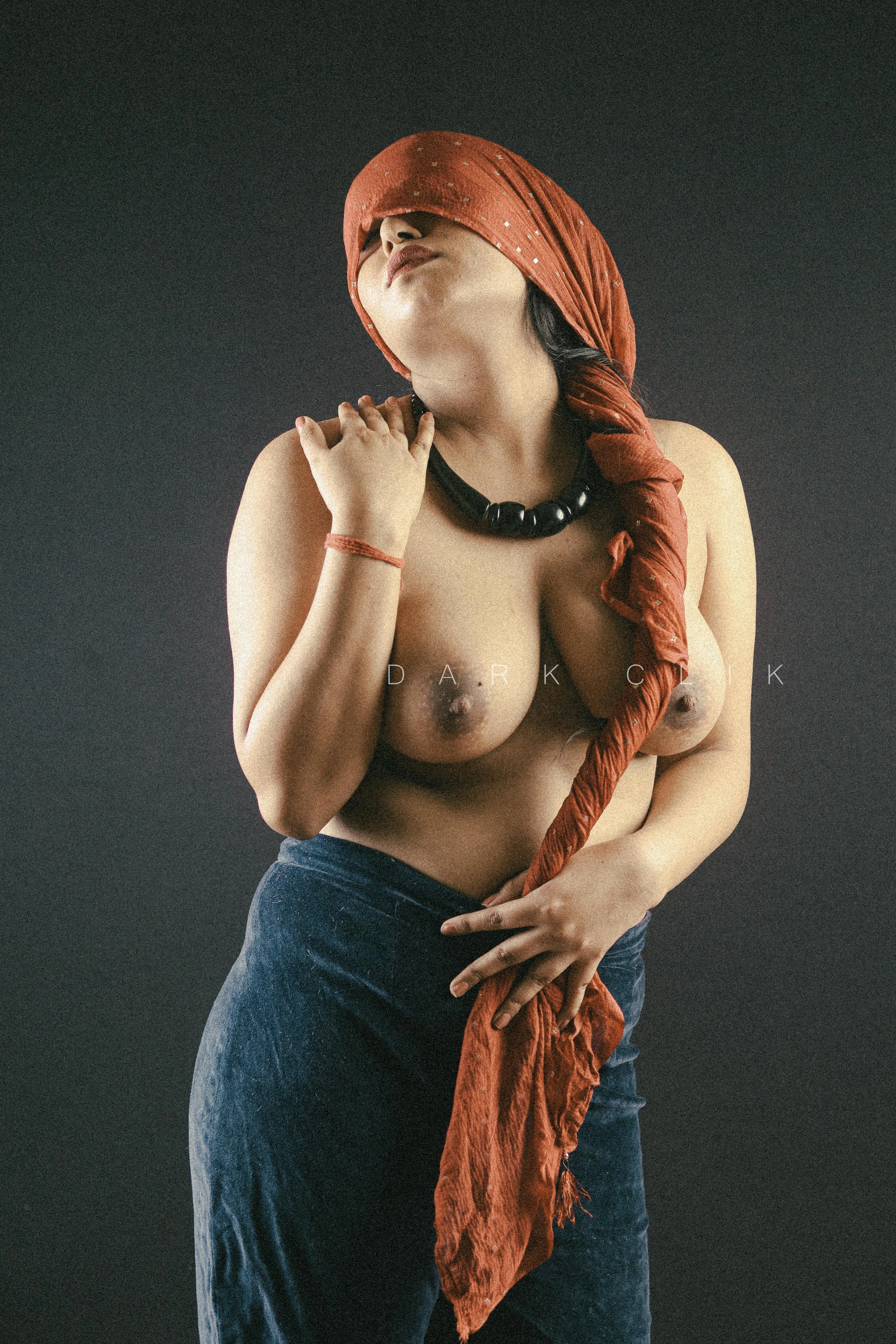 Desi MILF model hiding her face with red cloth and shows her big topless boobs while wearing blue pants