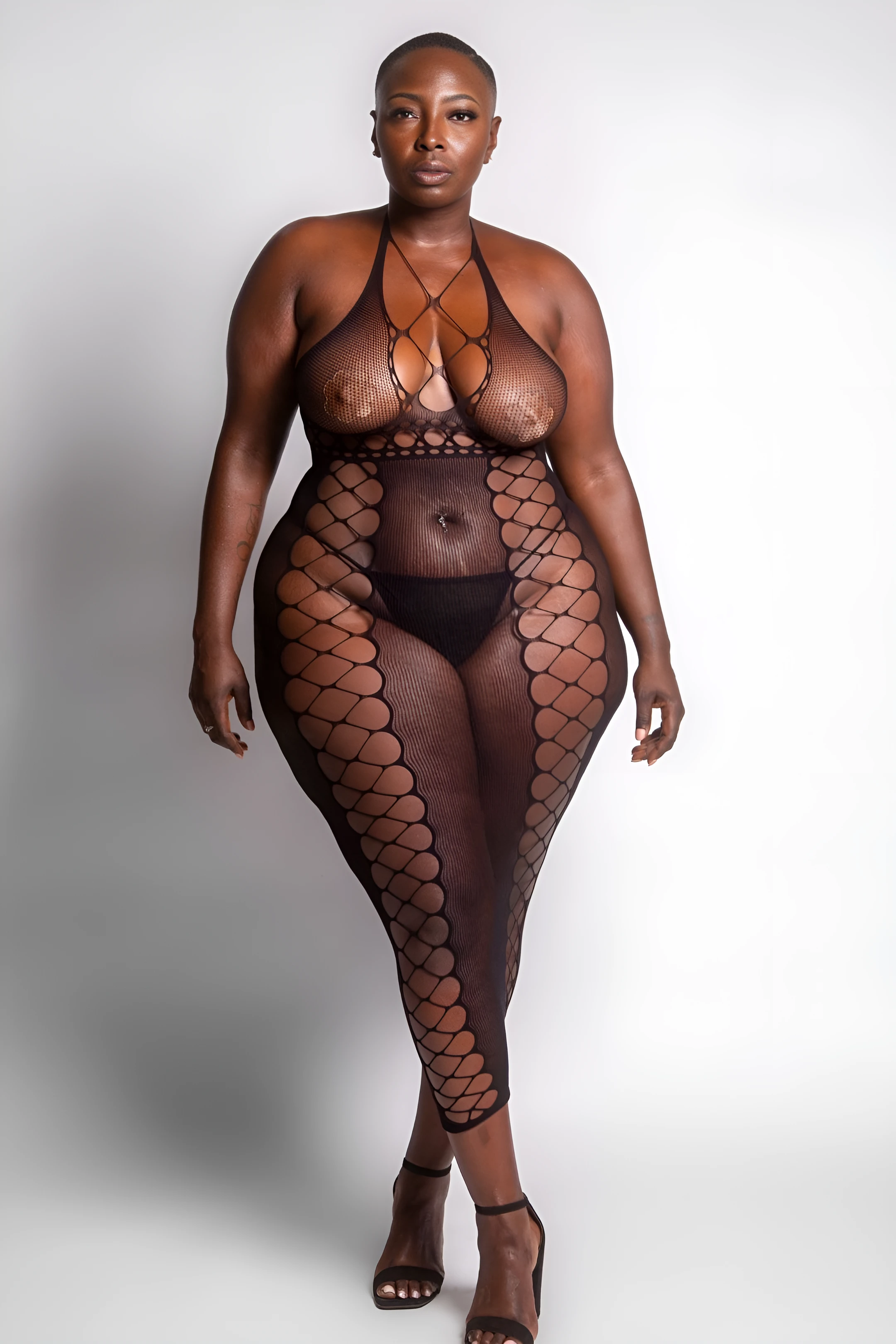 Ebony MILF model tempting with her big tits with nipple pasties while wearing a black sheer bodysuit lingerie
