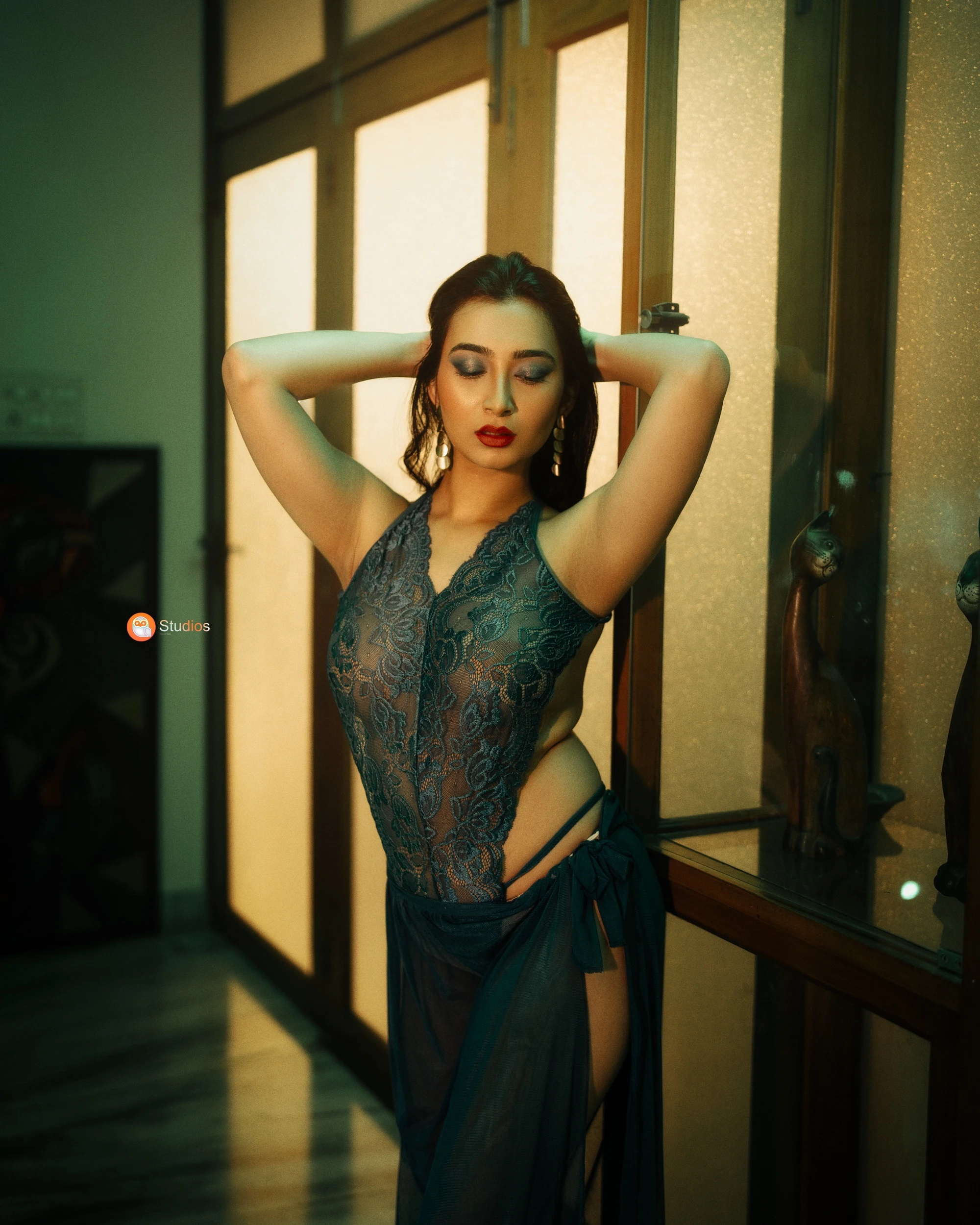 Desi MILF model shows her big boobs confined in a dark green lace lingerie while posing with her hands behind her head