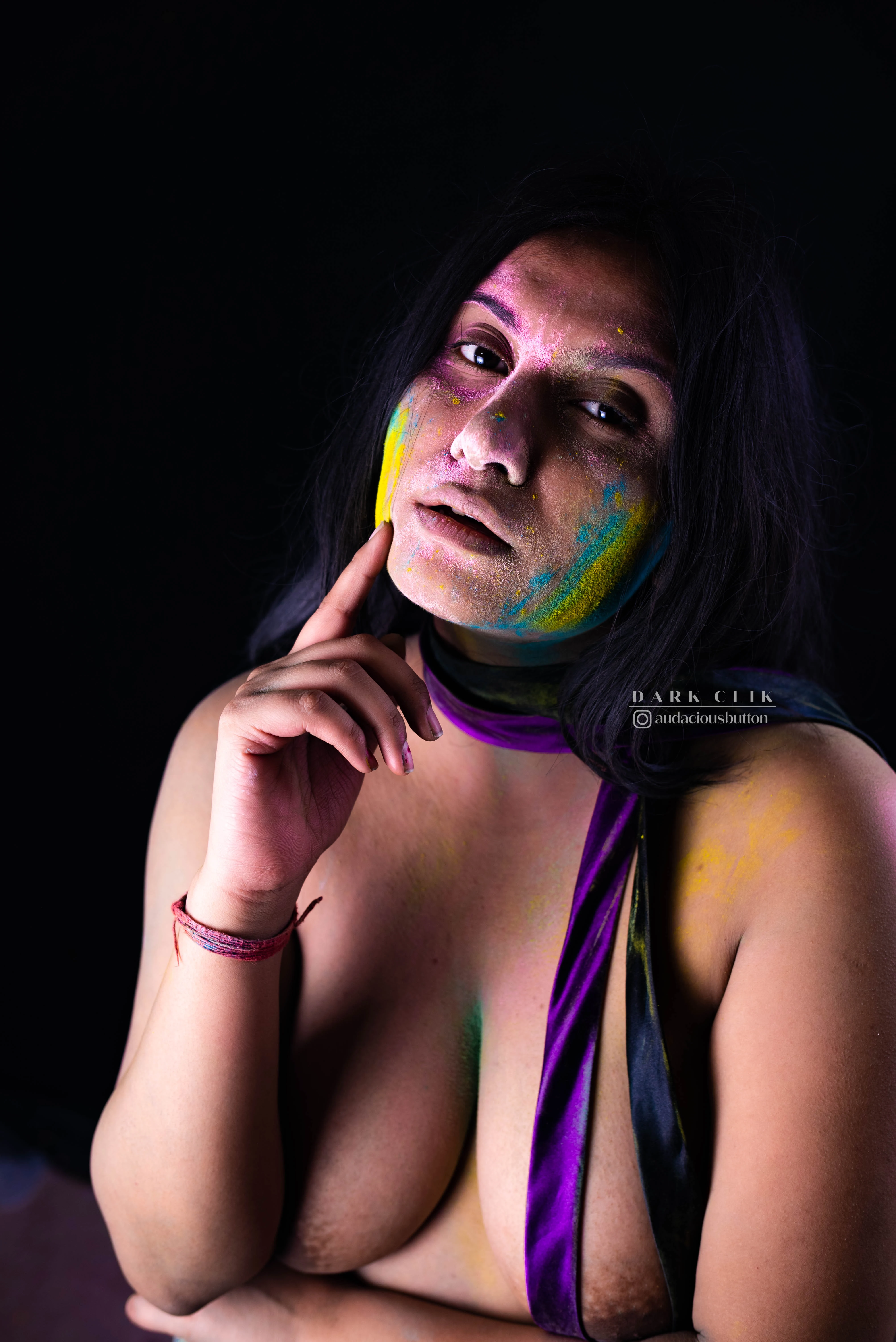 Desi MILF model with holi colors on her face hides her big tits with a purple cloth and arms