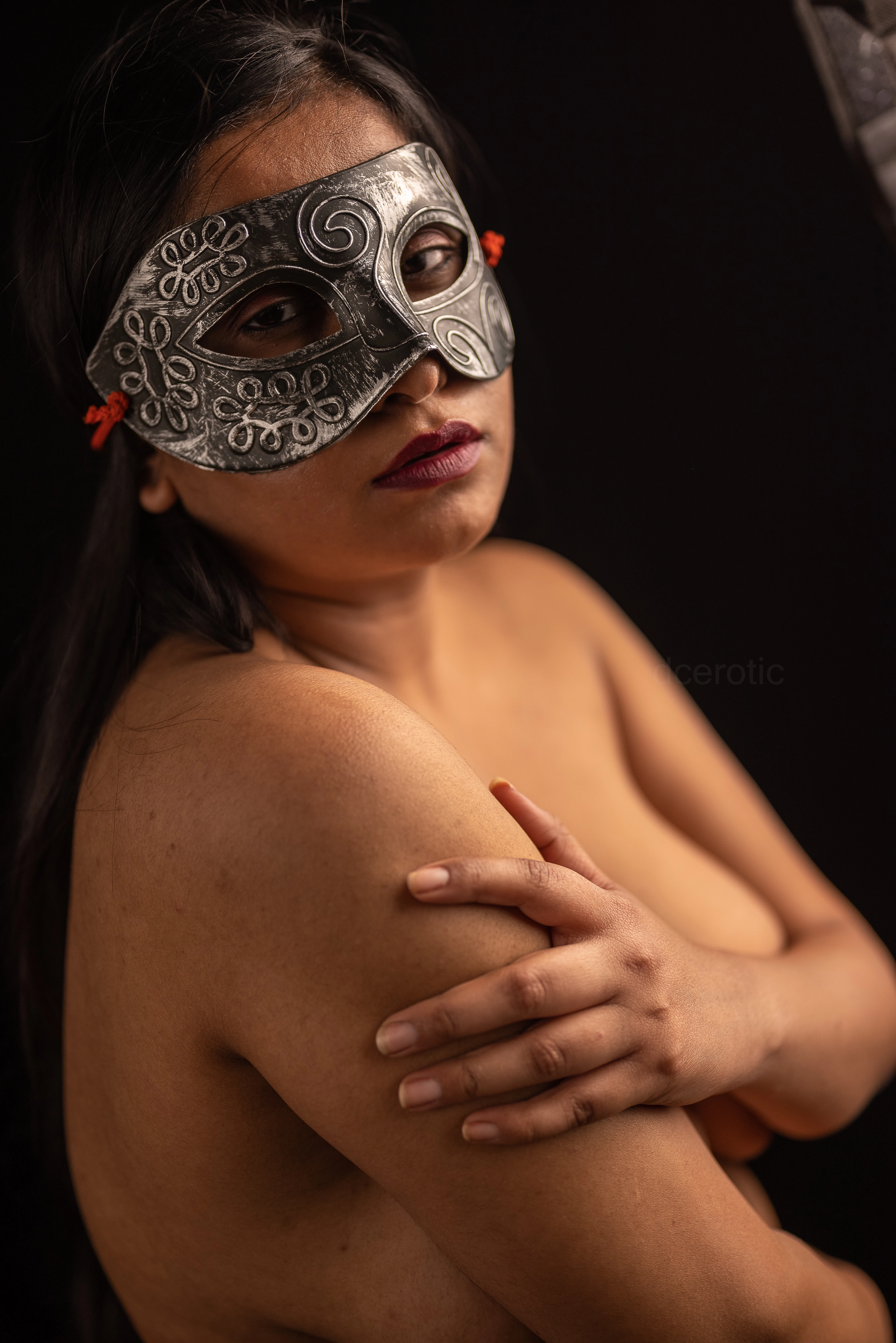 Desi MILF model wearing eye mask and covers her topless big boobs with her arms