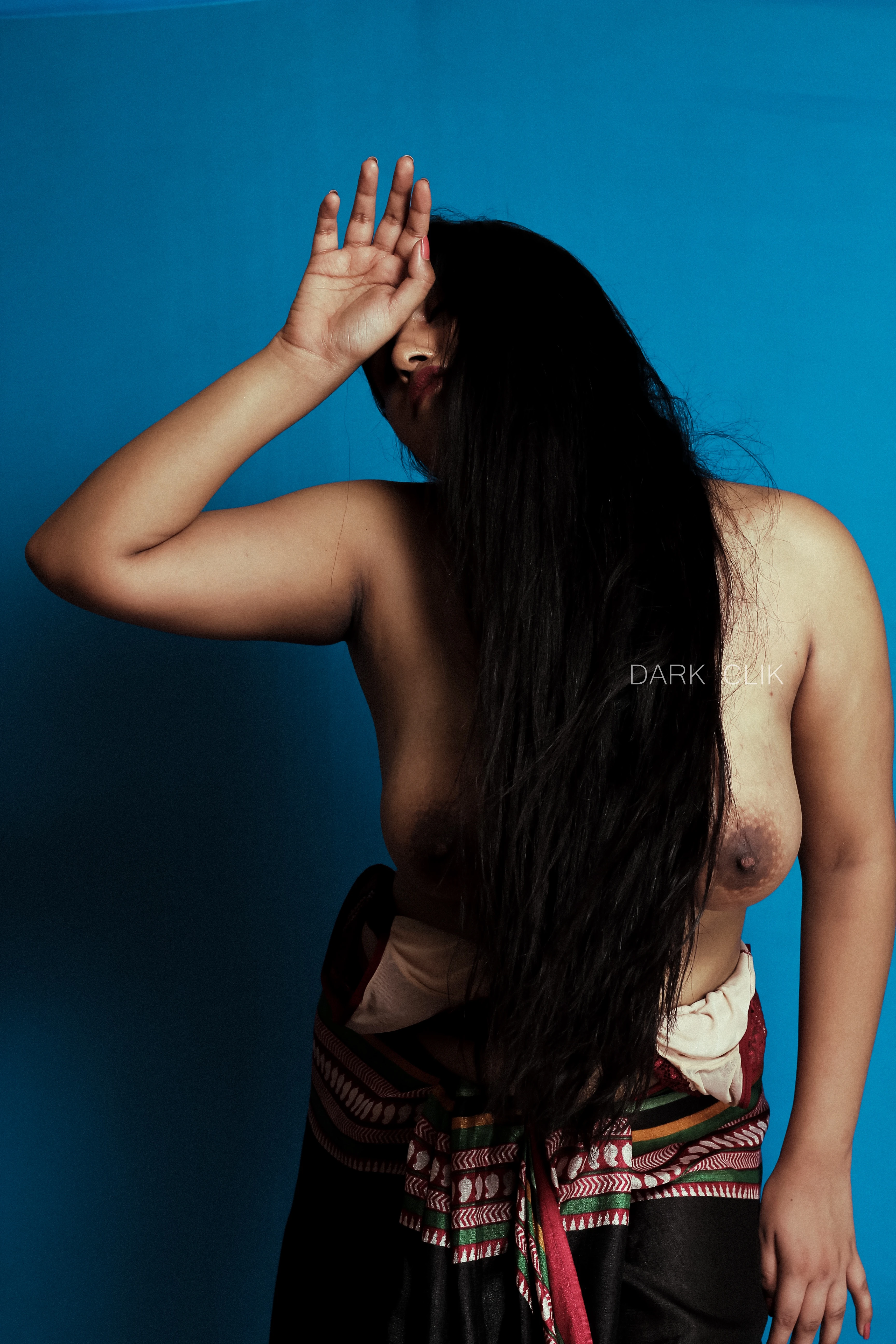 Desi MILF model raises her hand and posing in a black saree around her hips and showing her topless big tits