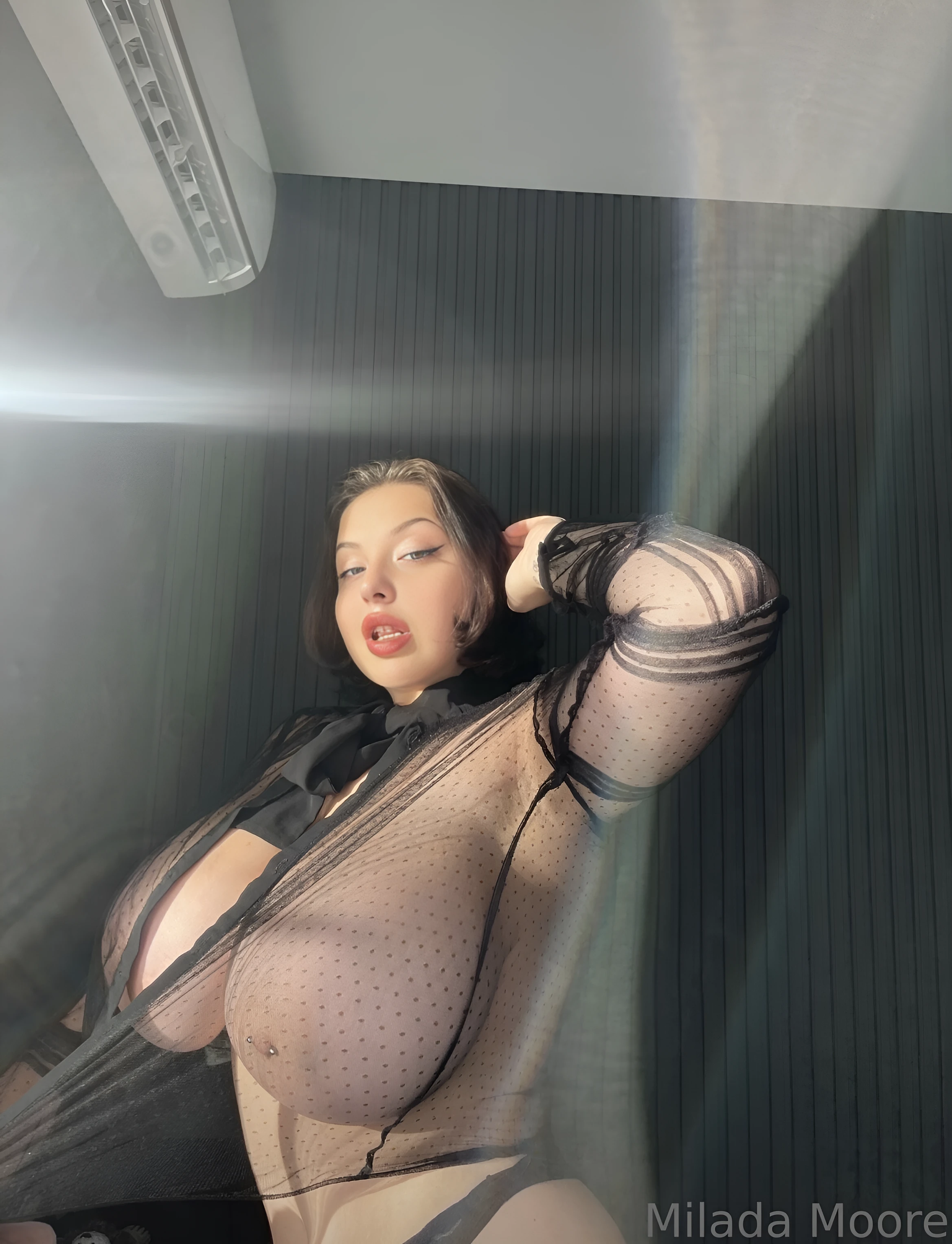 Provocative busty lady shows her big tits in a transparent black lingerie to command attention