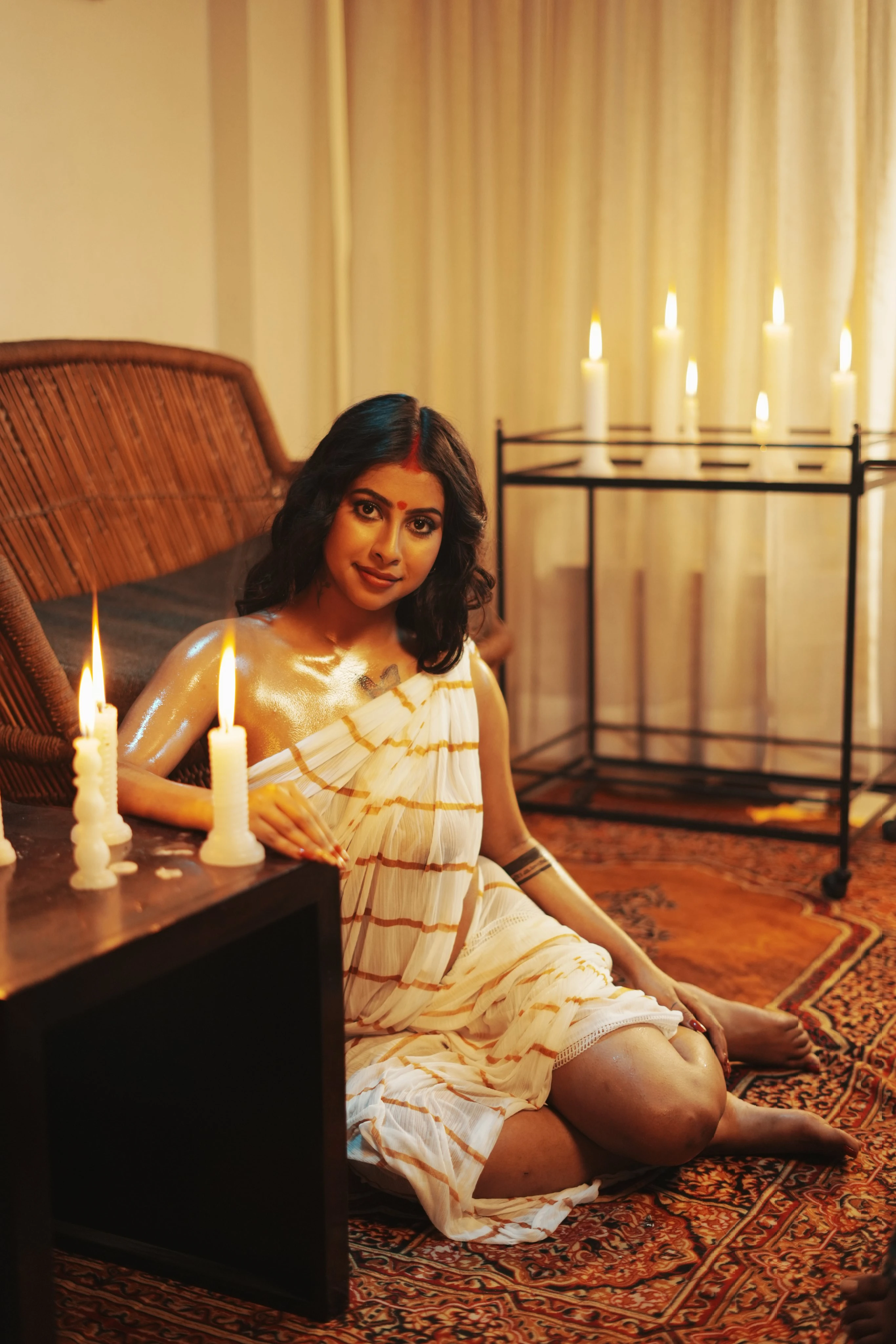Hot Desi model poses in a white braless saree and showing her boobs through it while posing near candles