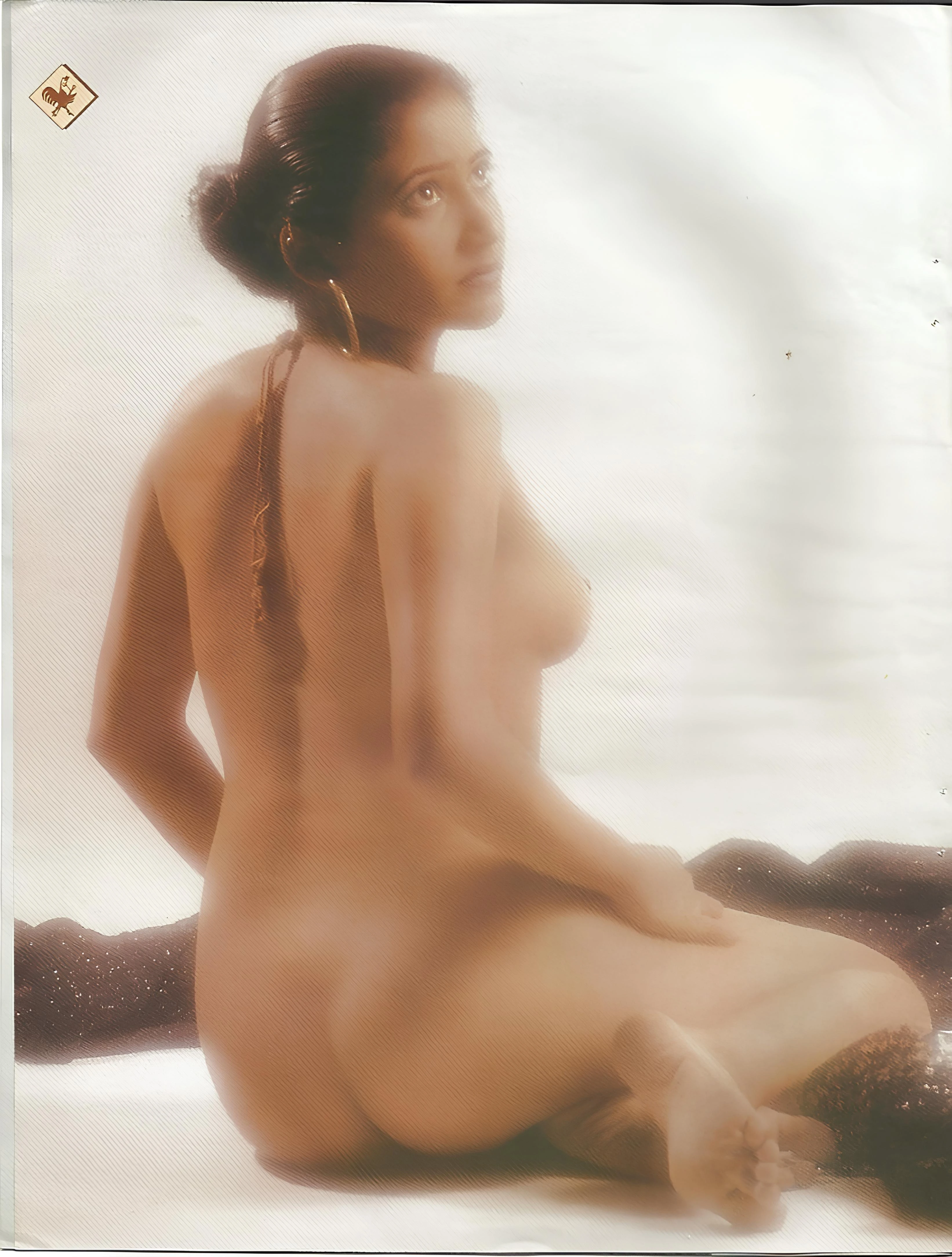 Nude Desi woman arches her back to show her smooth round ass and perky tits, her pussy hidden as she looks back over her shoulder