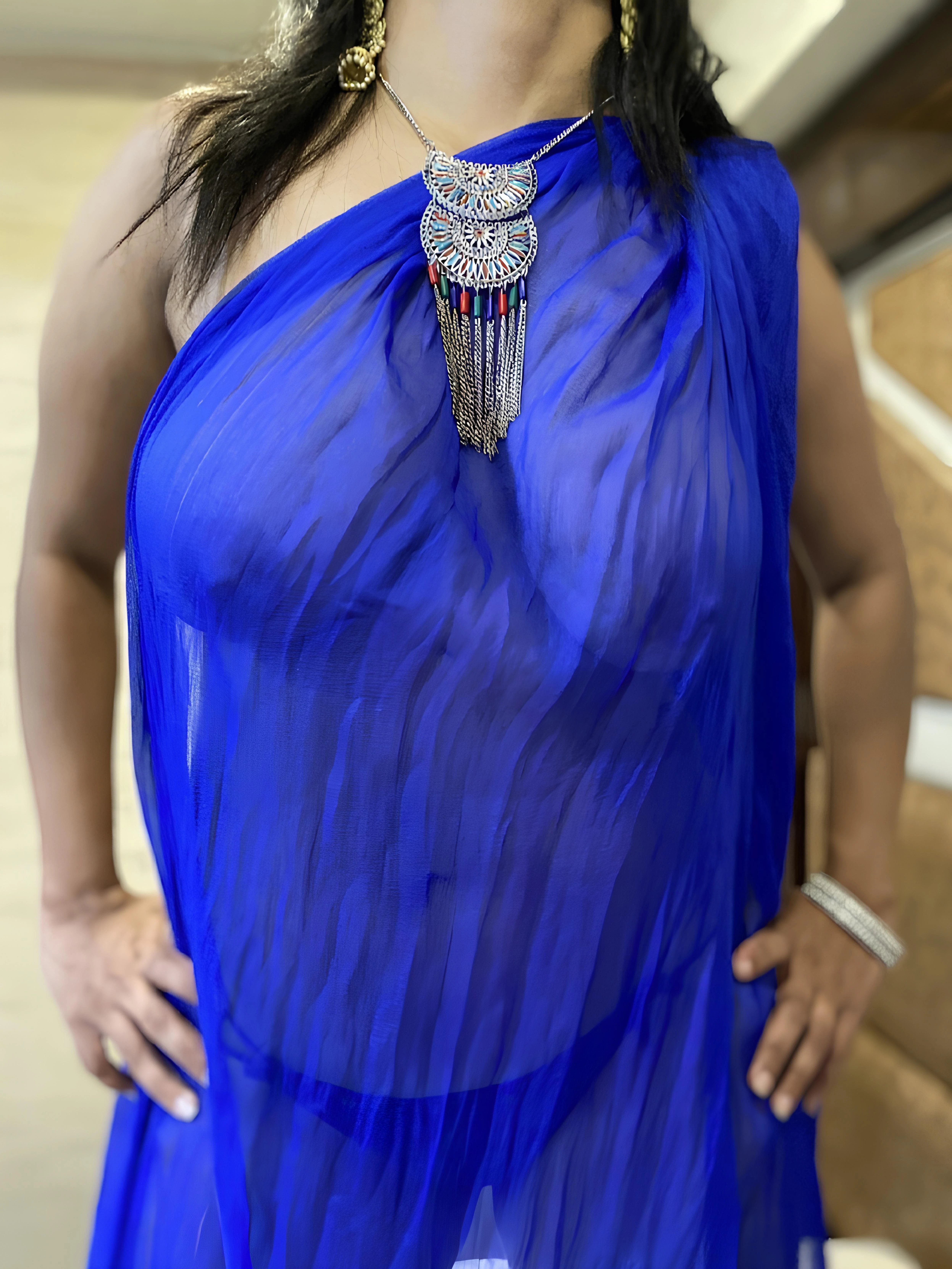 Desi girl draped in a vibrant blue braless saree and showing her naked big boobs, adorned with jewelry, exuding elegance and confidence