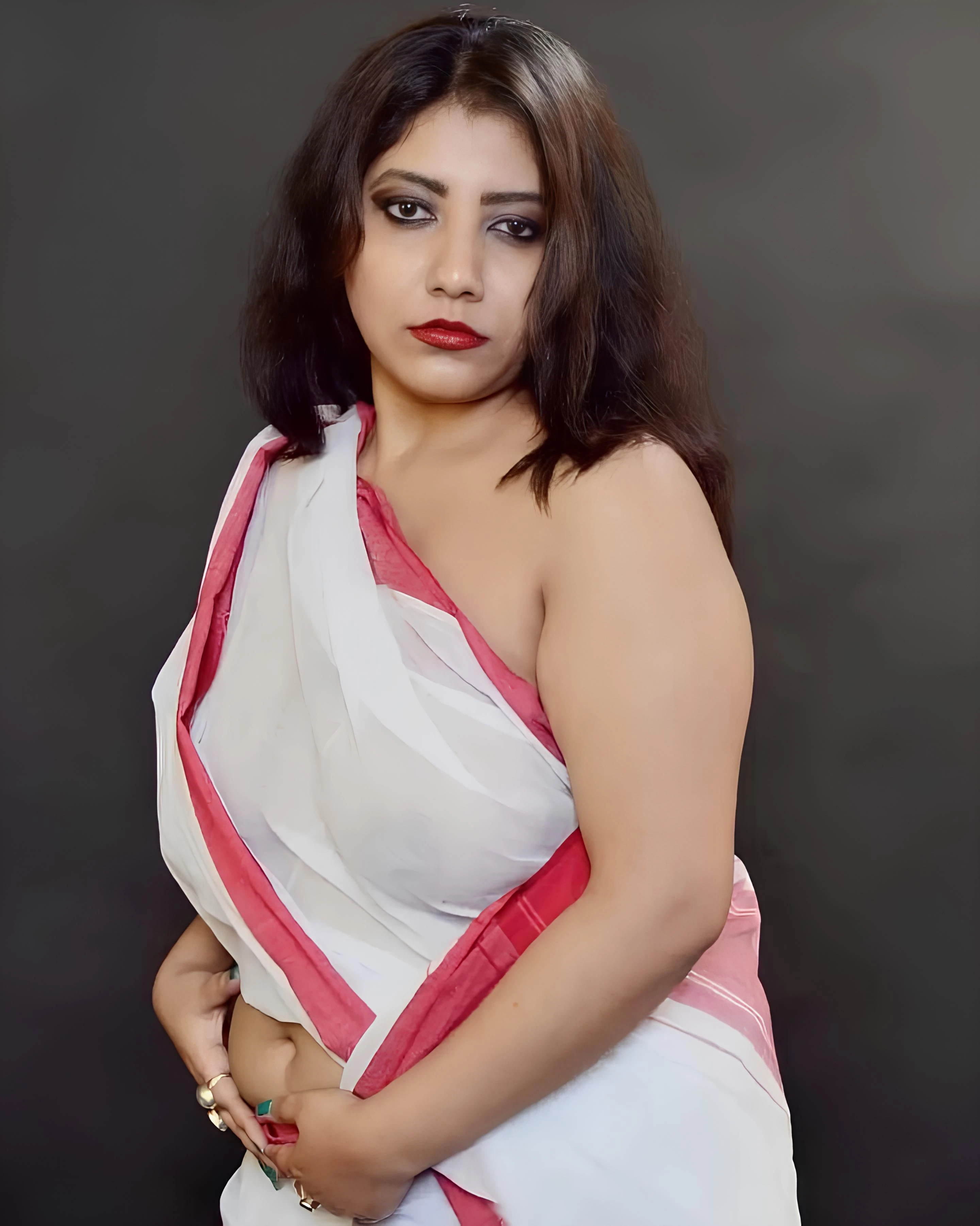 Desi MILF hides her naked tits clearly in a braless white saree with red border