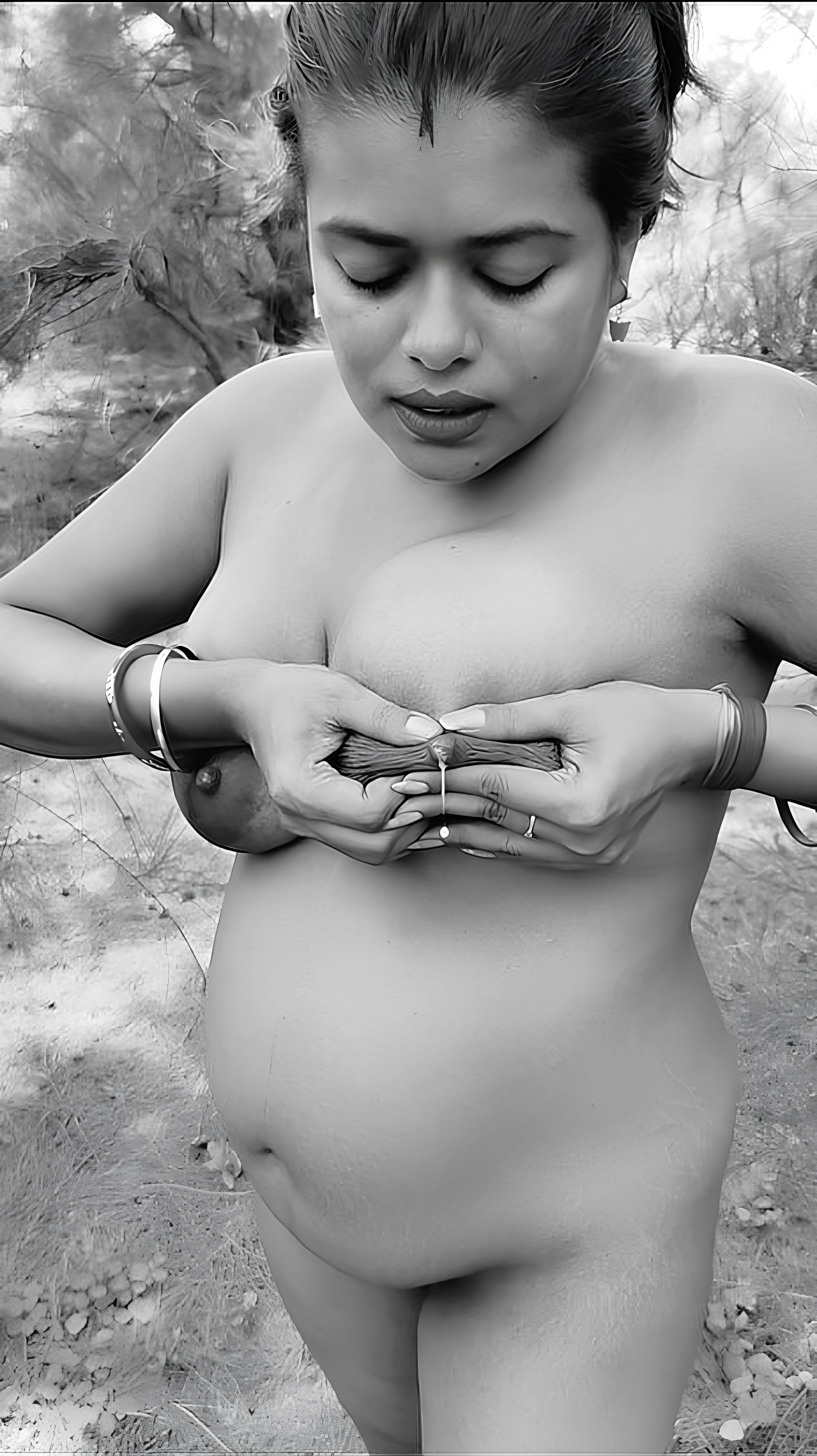 Nude Desi MILF stands outdoors cradling leaking heavy brown tits, dark nipples dripping milk while bangles glint in sunlight