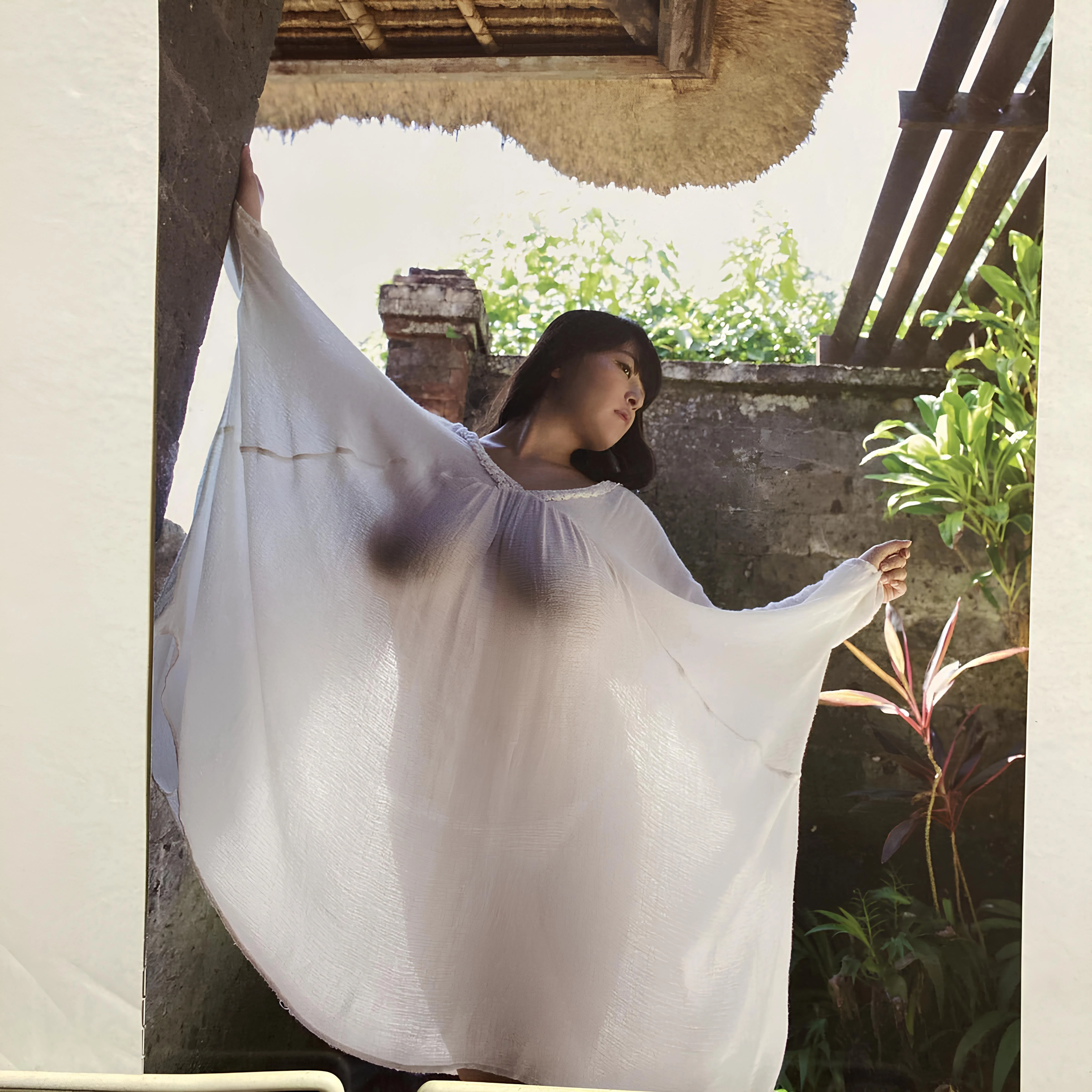 Japanese goddess Yanase Saki poses in sheer white kaftan under tropical sun, full naked curves and dark nipples glowing through translucent fabric