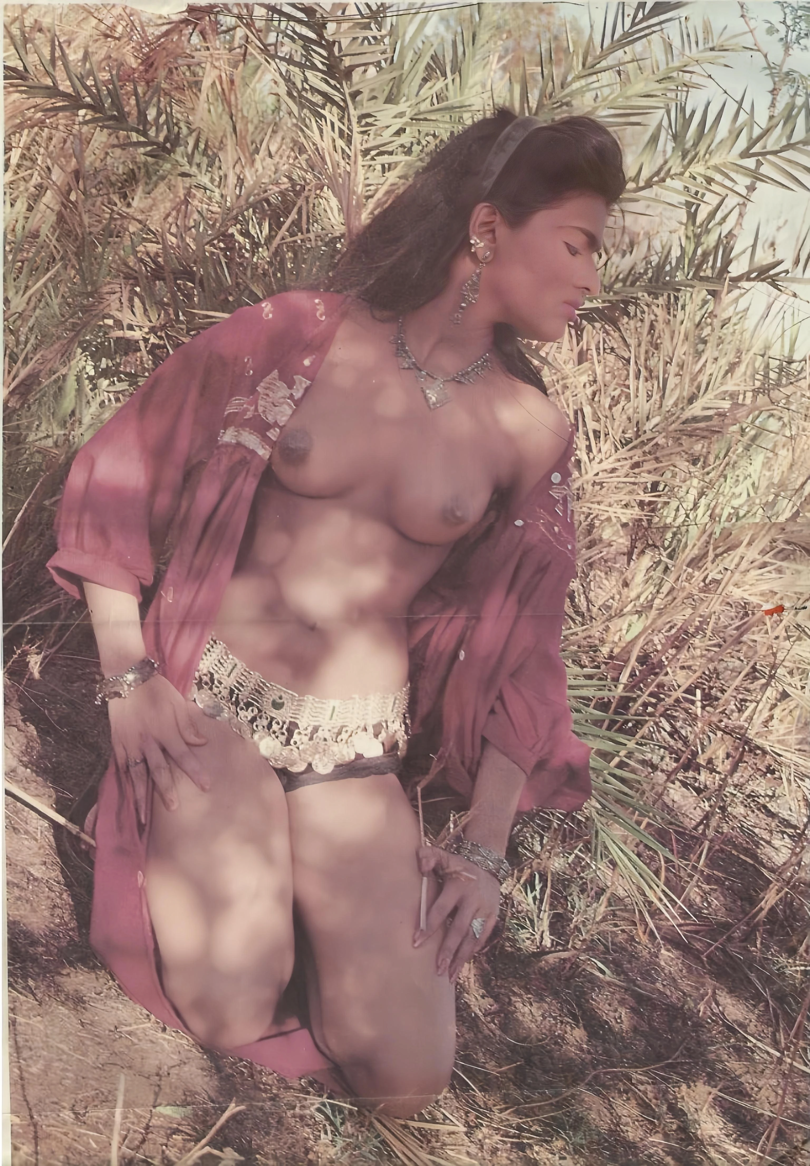 Petite Desi vintage model kneels topless in open pink robe baring perky tits with erect brown nipples in outdoor