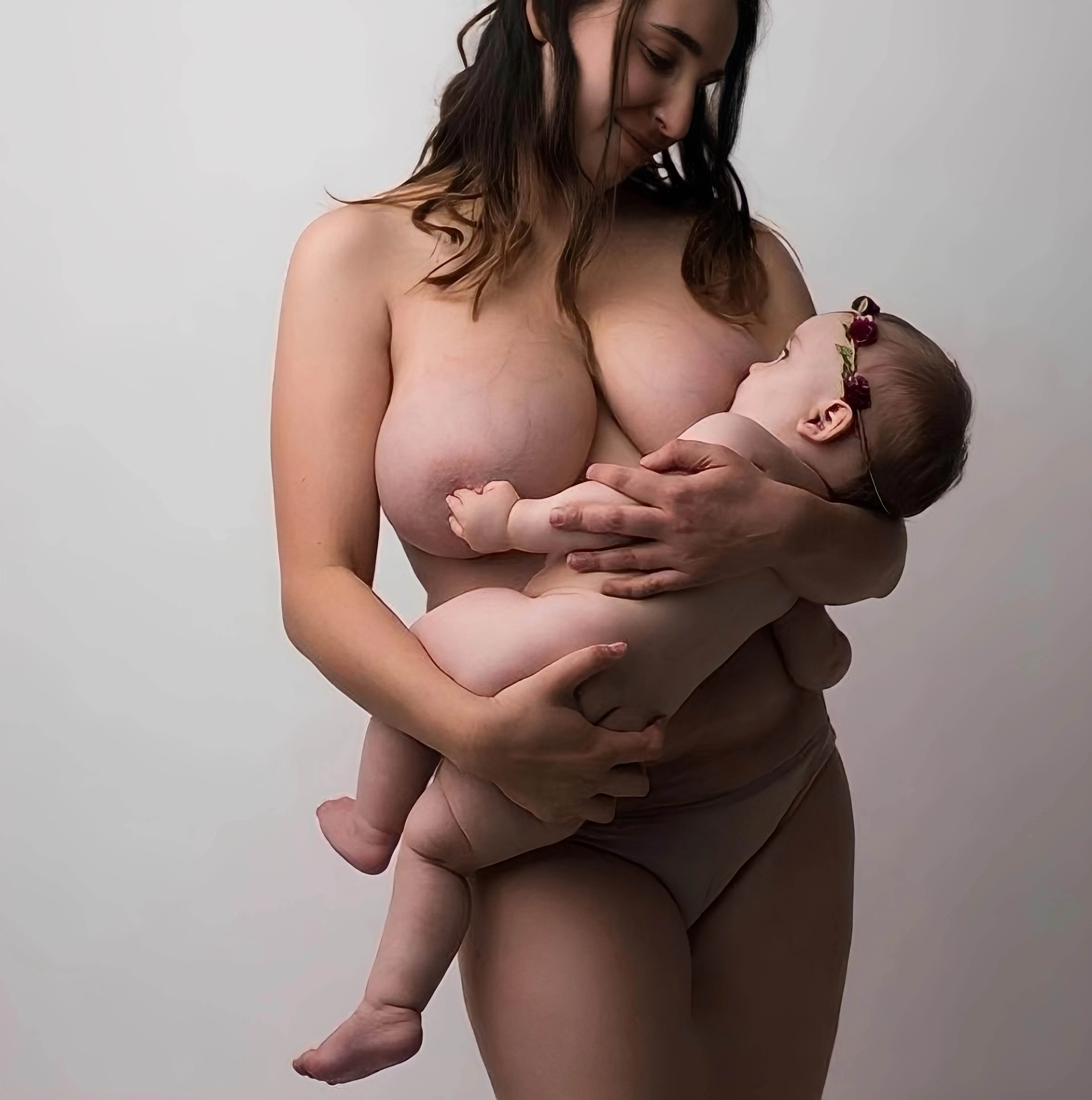 Topless woman breast feeds a baby, showcasing her full tits with visible veins