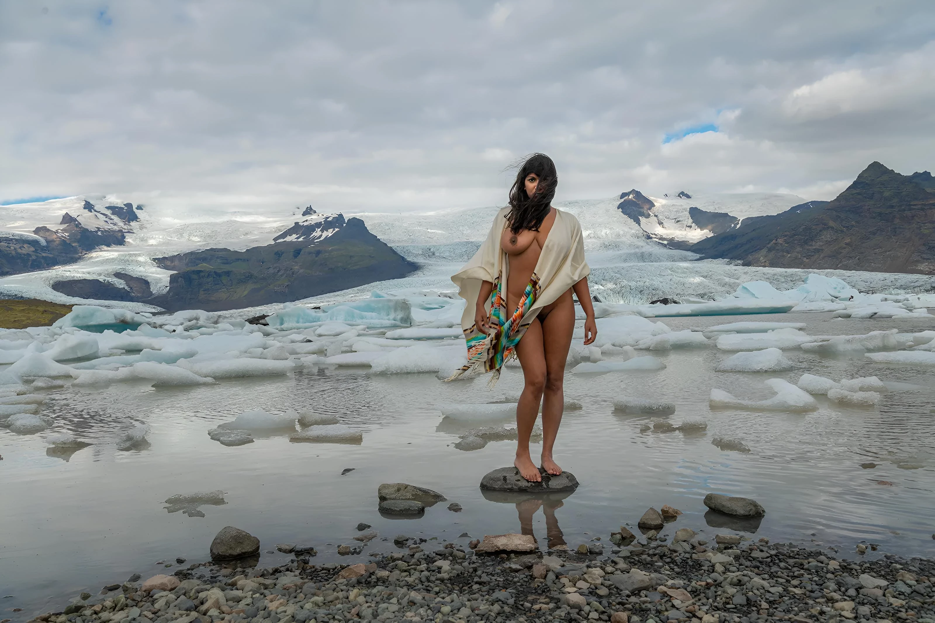 Stunning Desi model Dakini Carla White posing naked on a frozen glacial lake showing her firm D-cup tits and smooth shaved pussy
