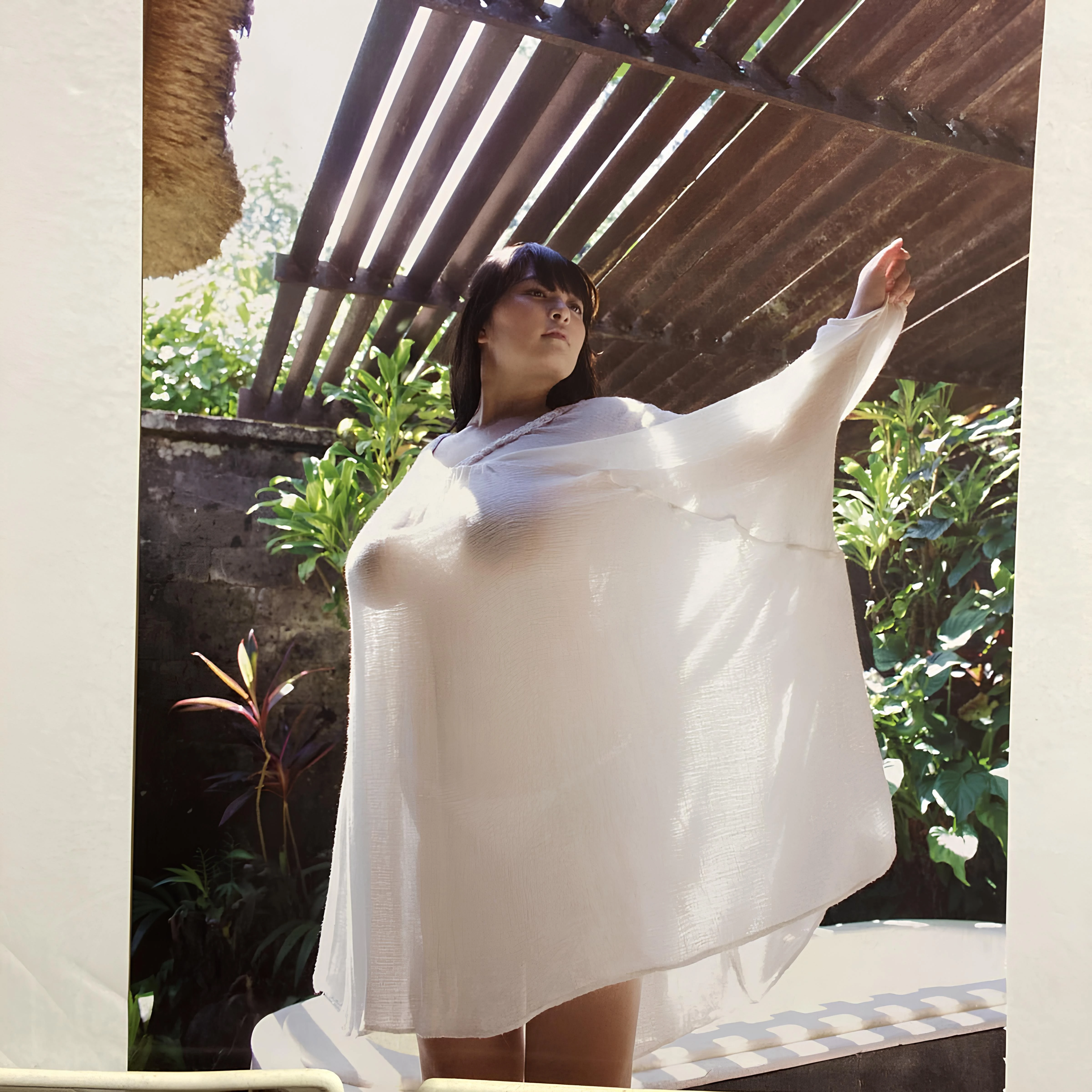 Yanase Saki posing outdoors in a gauzy wrap displaying her naked breasts and smooth tanned legs