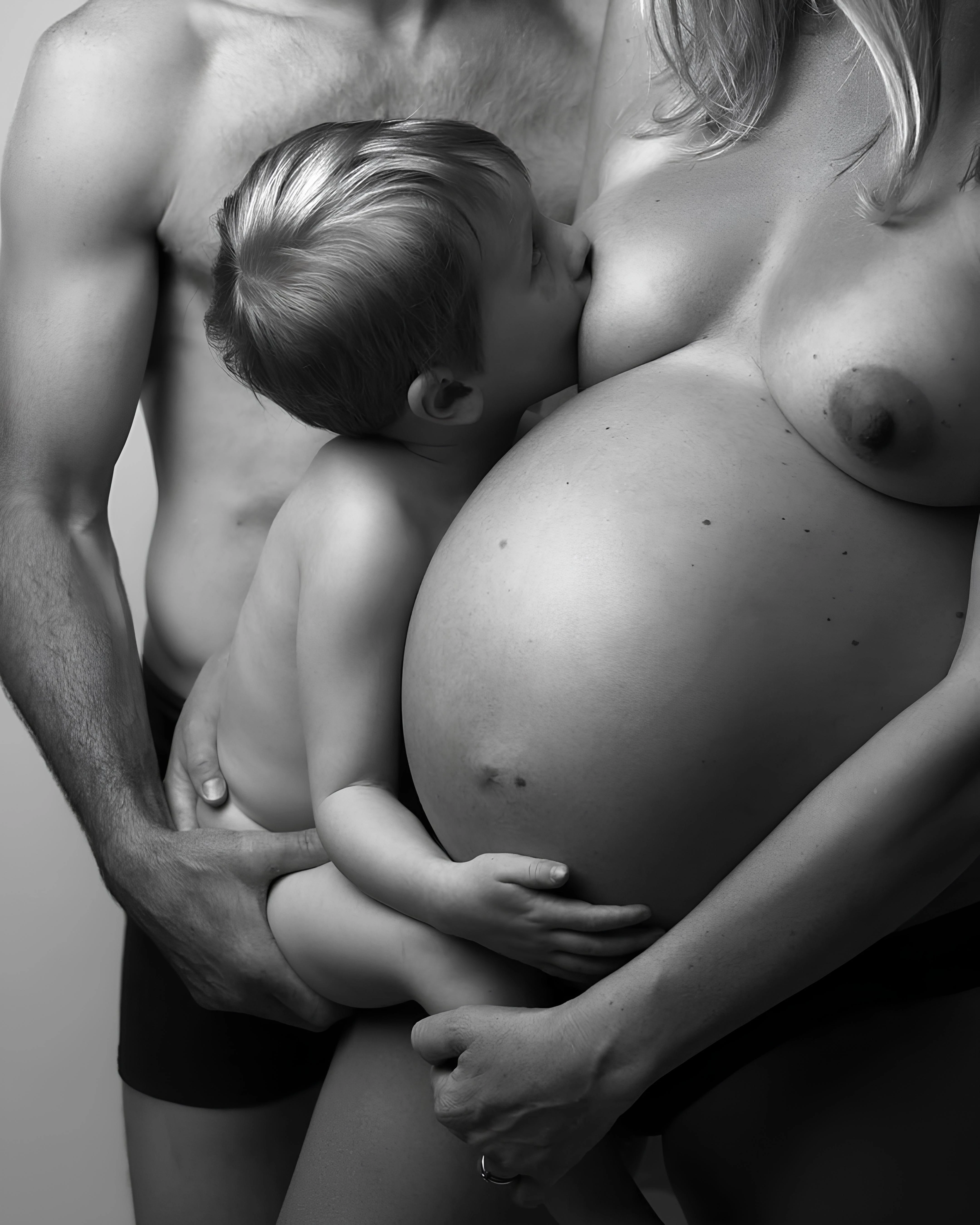 Pregnant woman posing along with her husband and feeding her baby and posing topless showing her big boobs