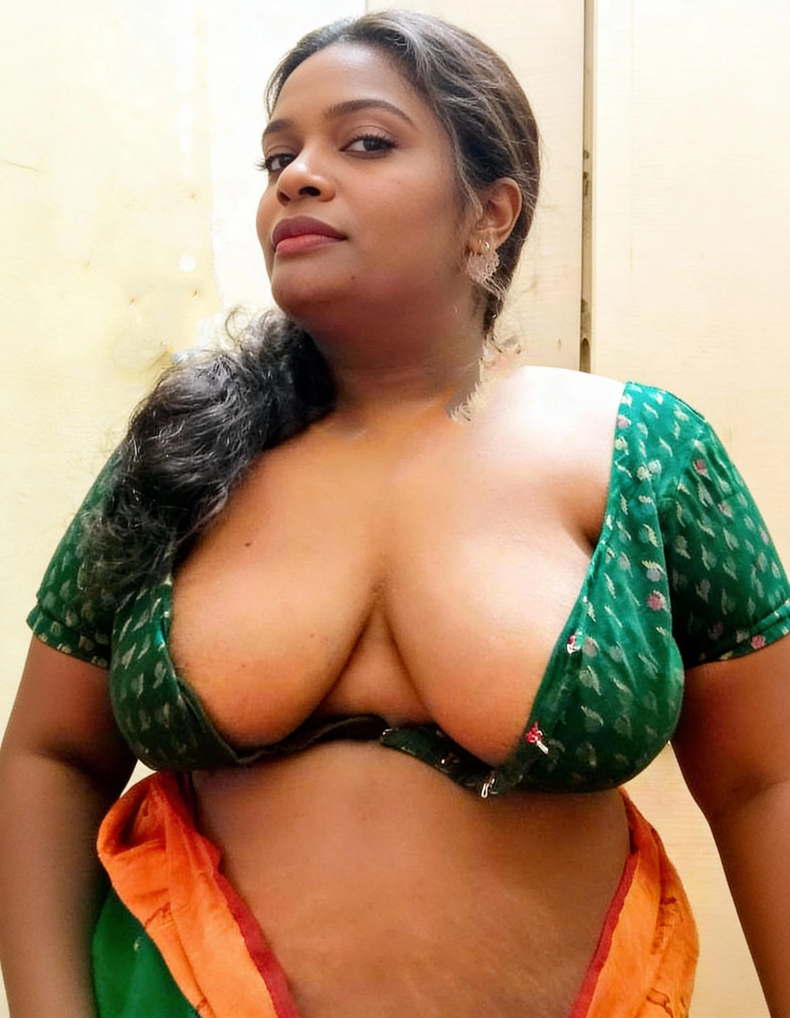 Busty Desi MILF posing with an open green blouse showing her bare rounded breasts