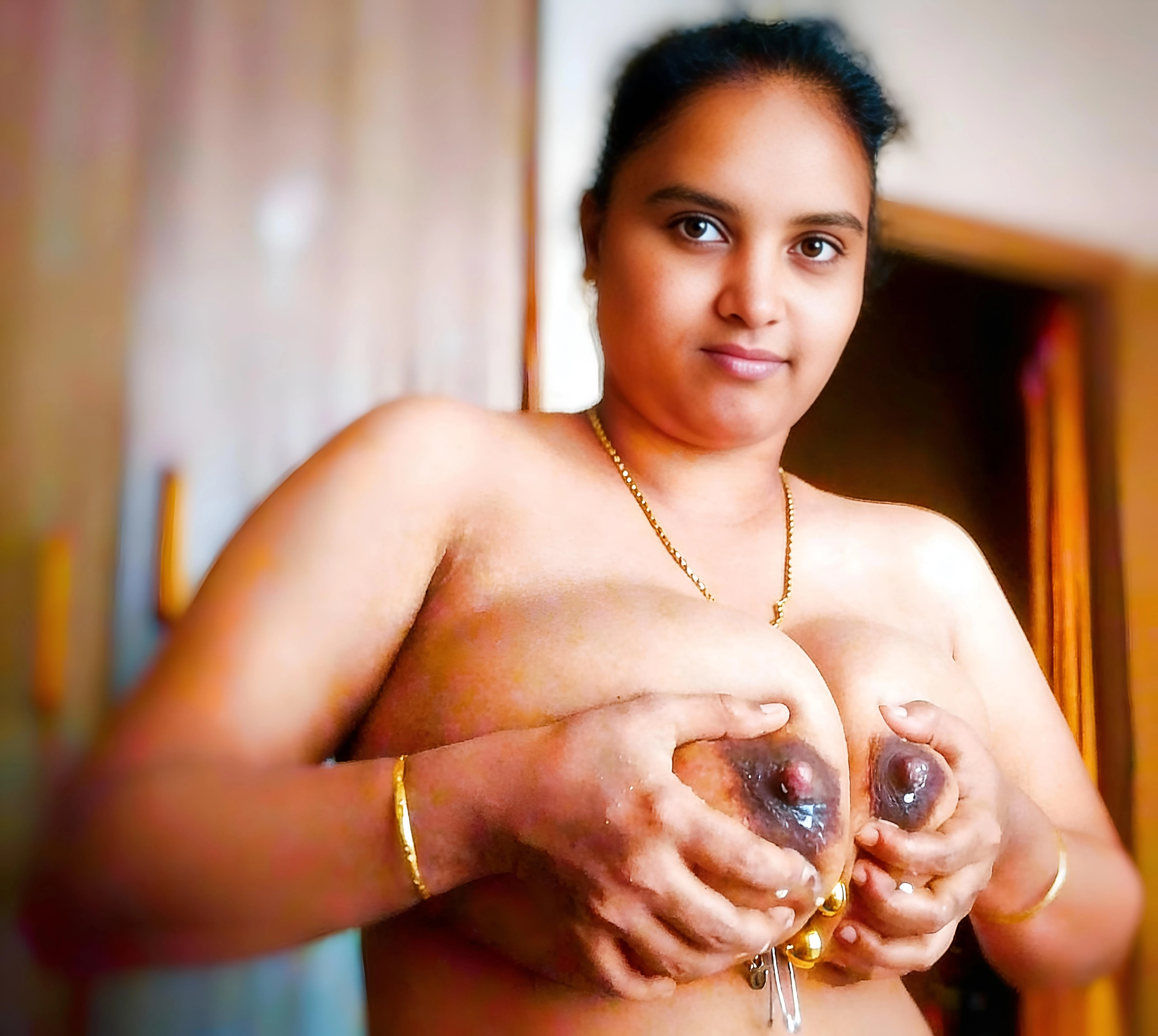 Full frontal topless Desi wife showing her bare breasts and puffy reddish-pink nipples with droplets of milk and a gold chain
