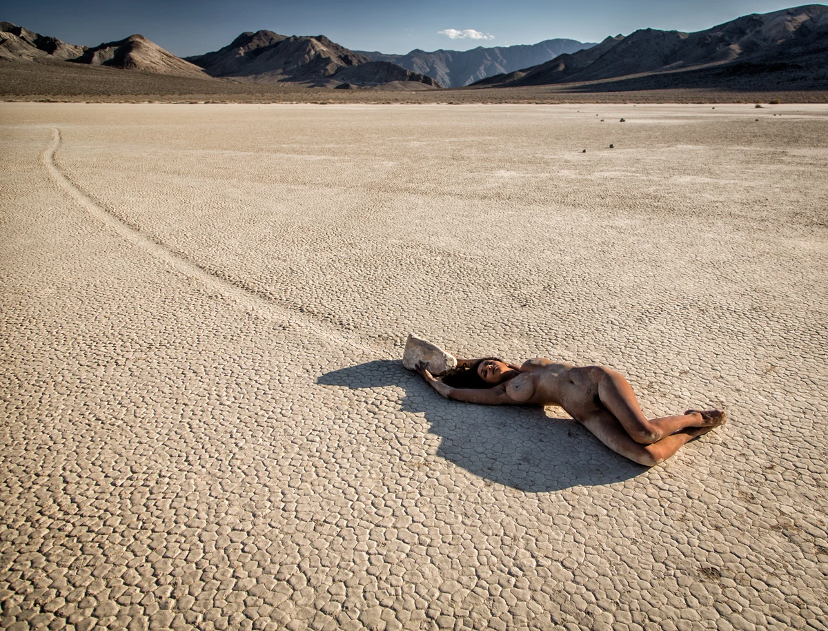 Fully nude Dakini lying on the desert floor showing her big boobs