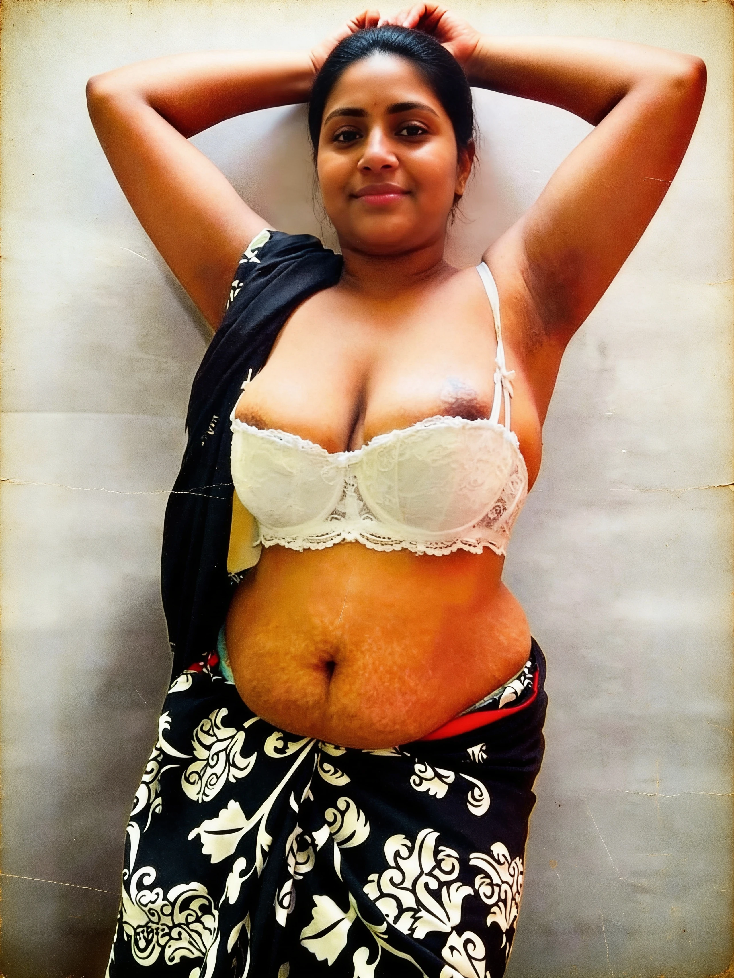 Desi woman with large tits and dark protruding nipples stands in low white lace bra while wearing black saree