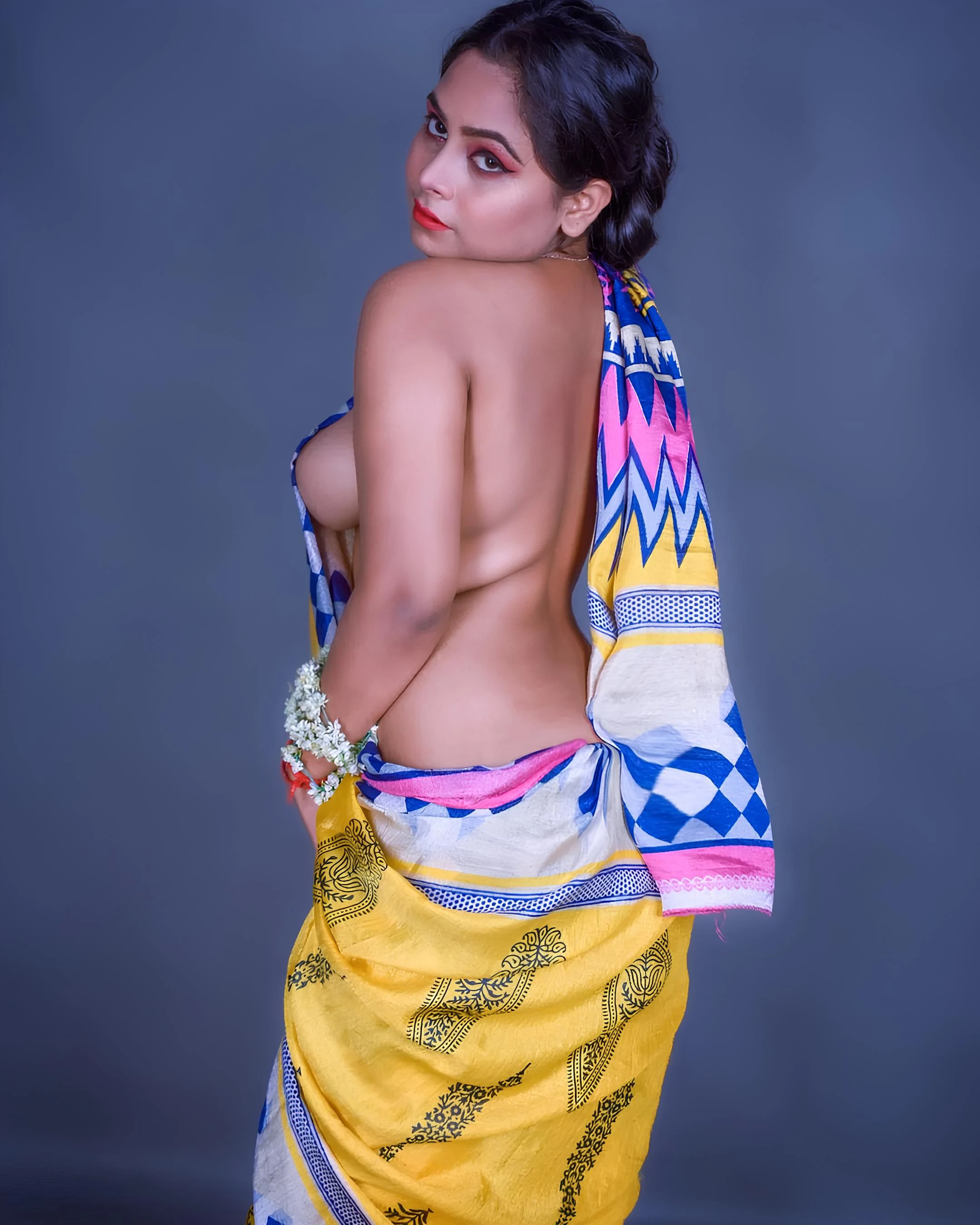 Desi model in braless yellow saree with rounded breast swell turns head over shoulder