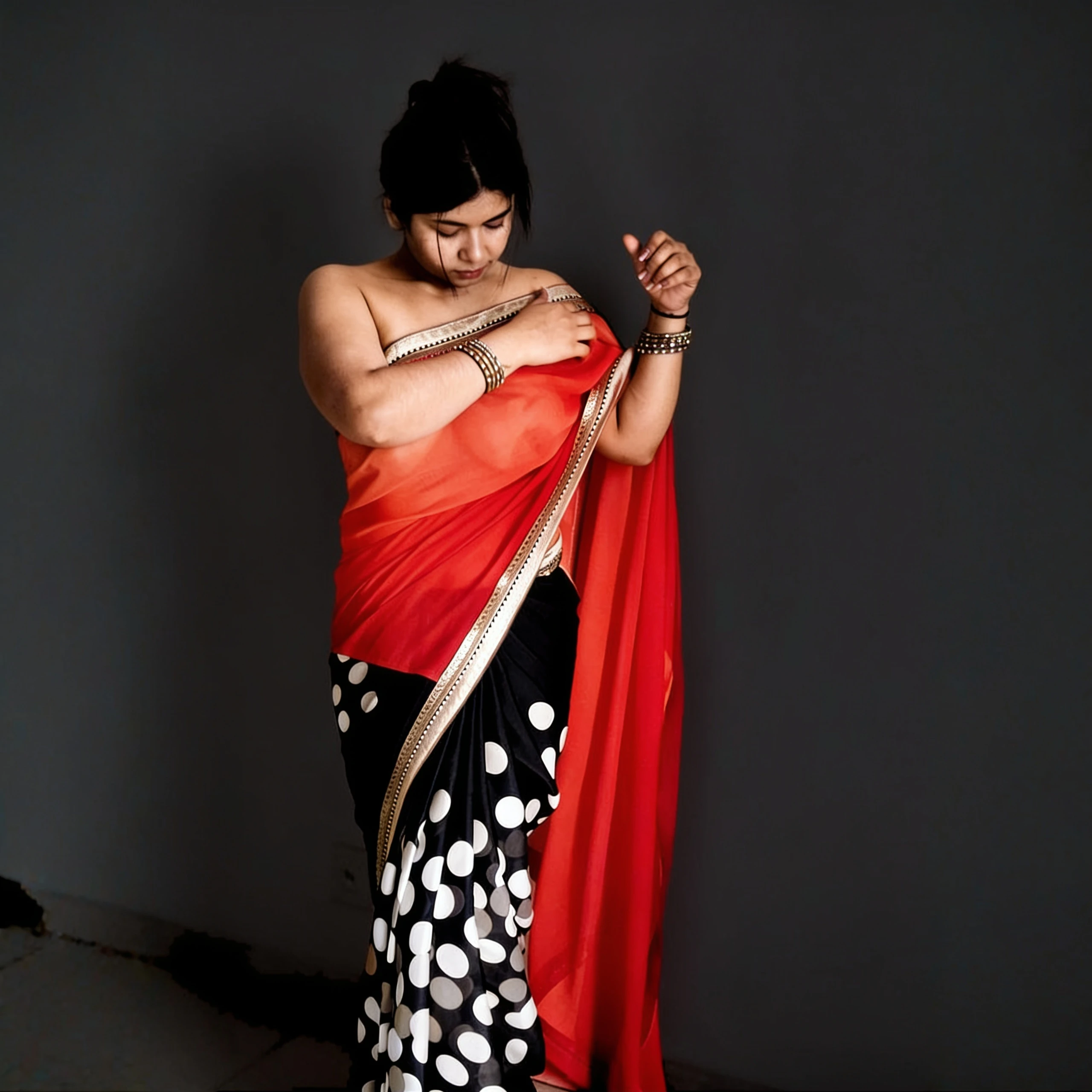 Desi woman in a braless thin red saree with black polka dots, exposed right shoulder, showing her naked boobs clearly