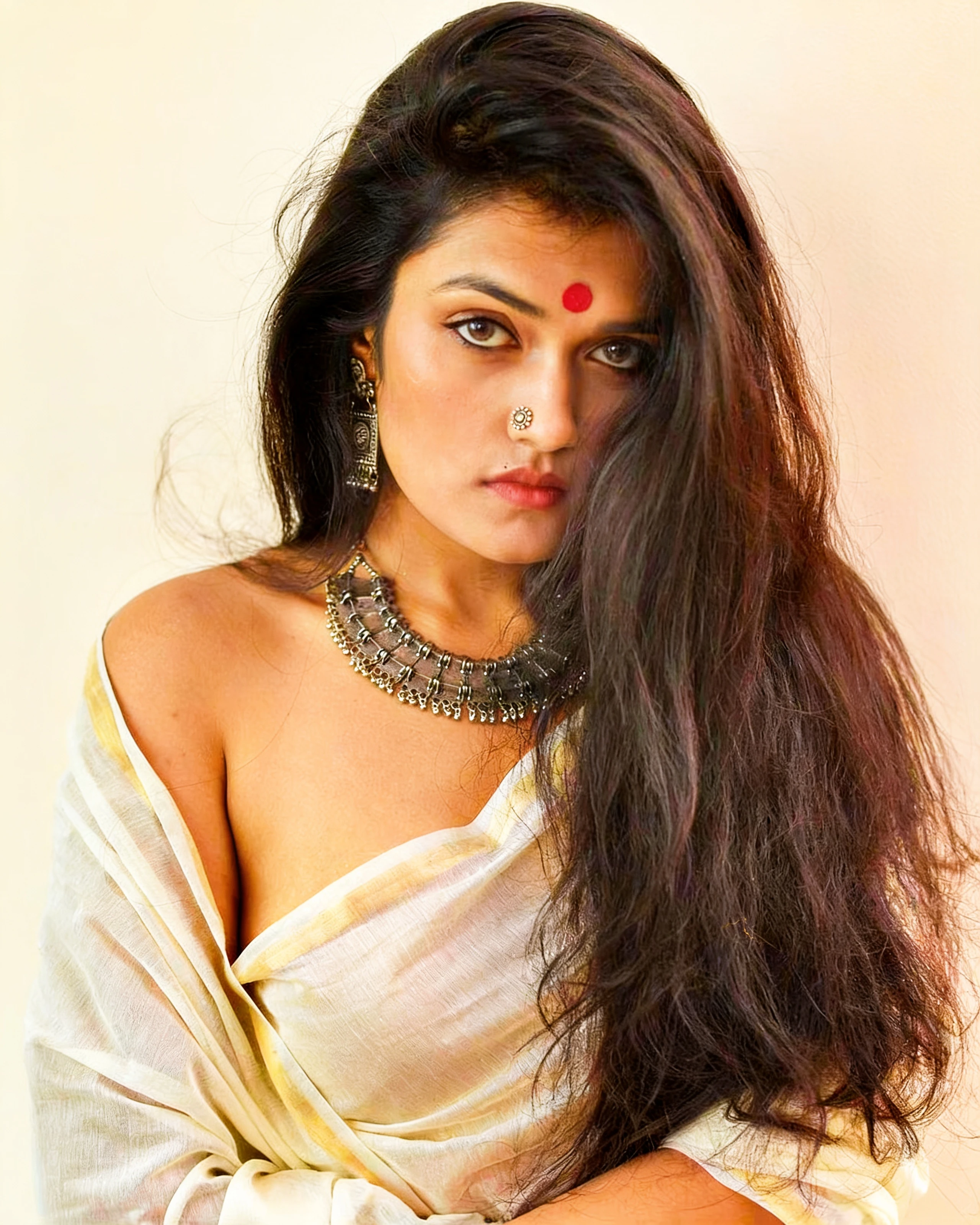 Desi model with bindi and silver jewelry in a braless saree but hiding her boobs